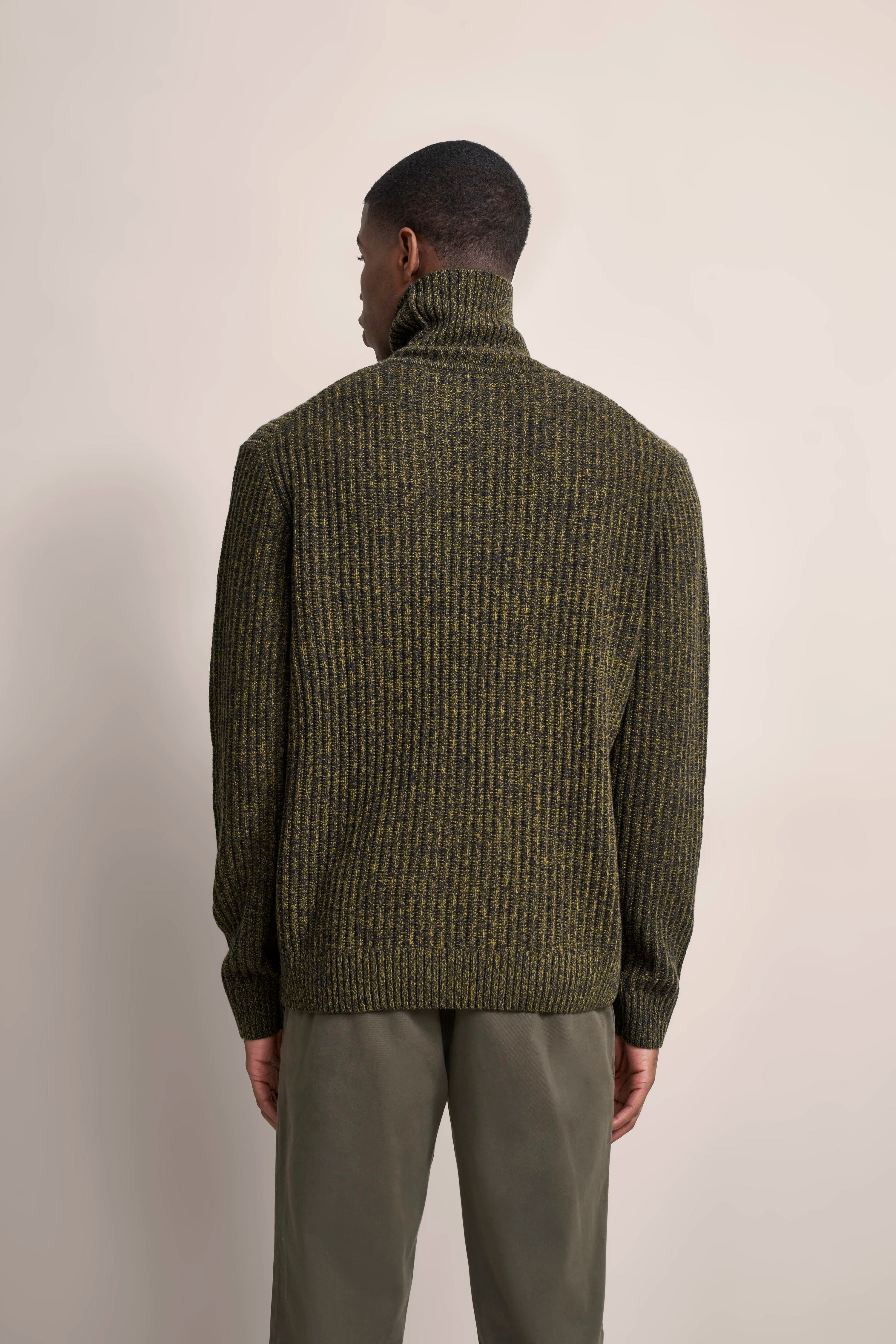 Rückansicht Model, olivgrüner Rollkragenpullover von bugatti, lässige Chinohose in Khaki.