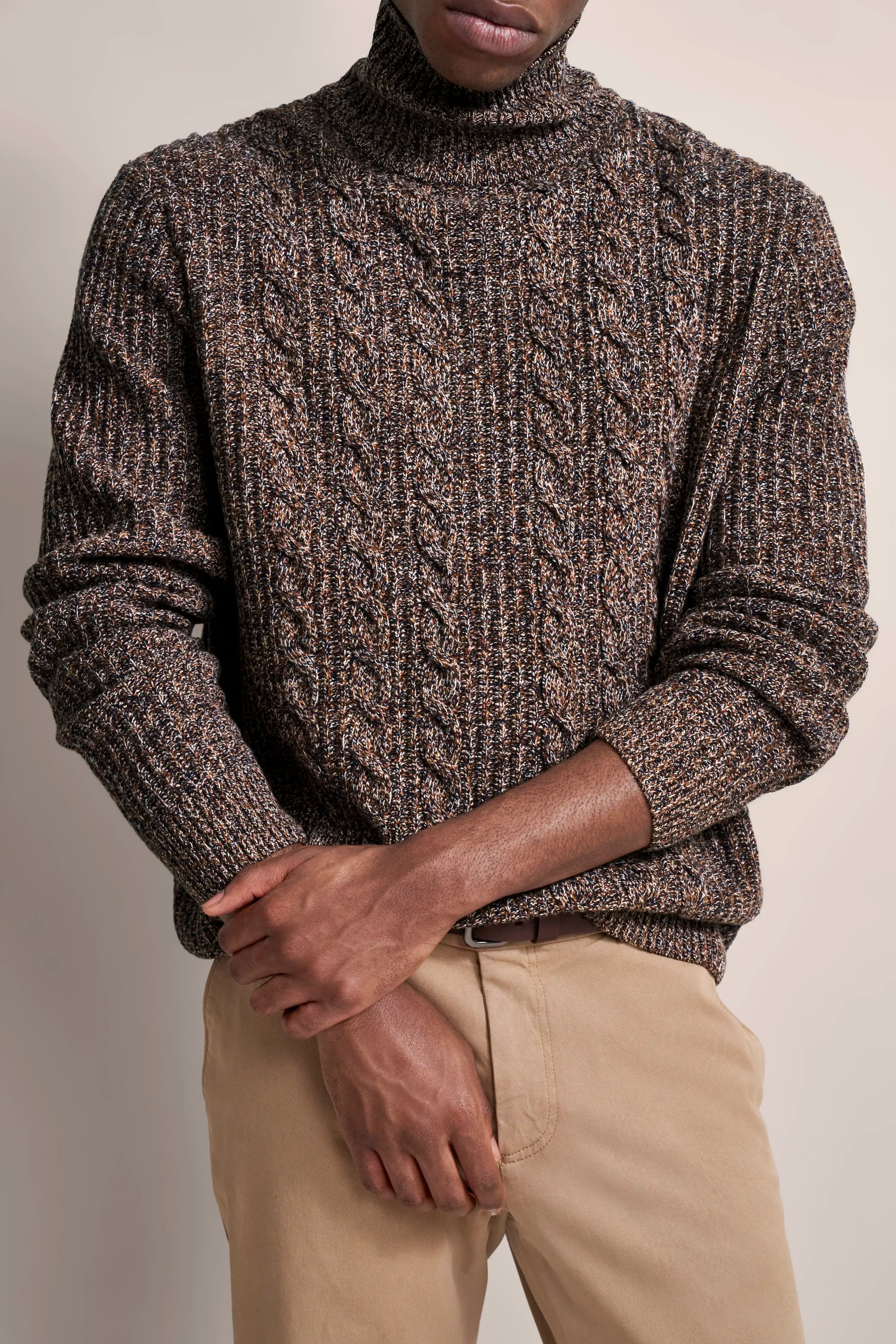 Brown melange turtleneck sweater, beige chinos. Model in relaxed pose. bugatti style and elegance.