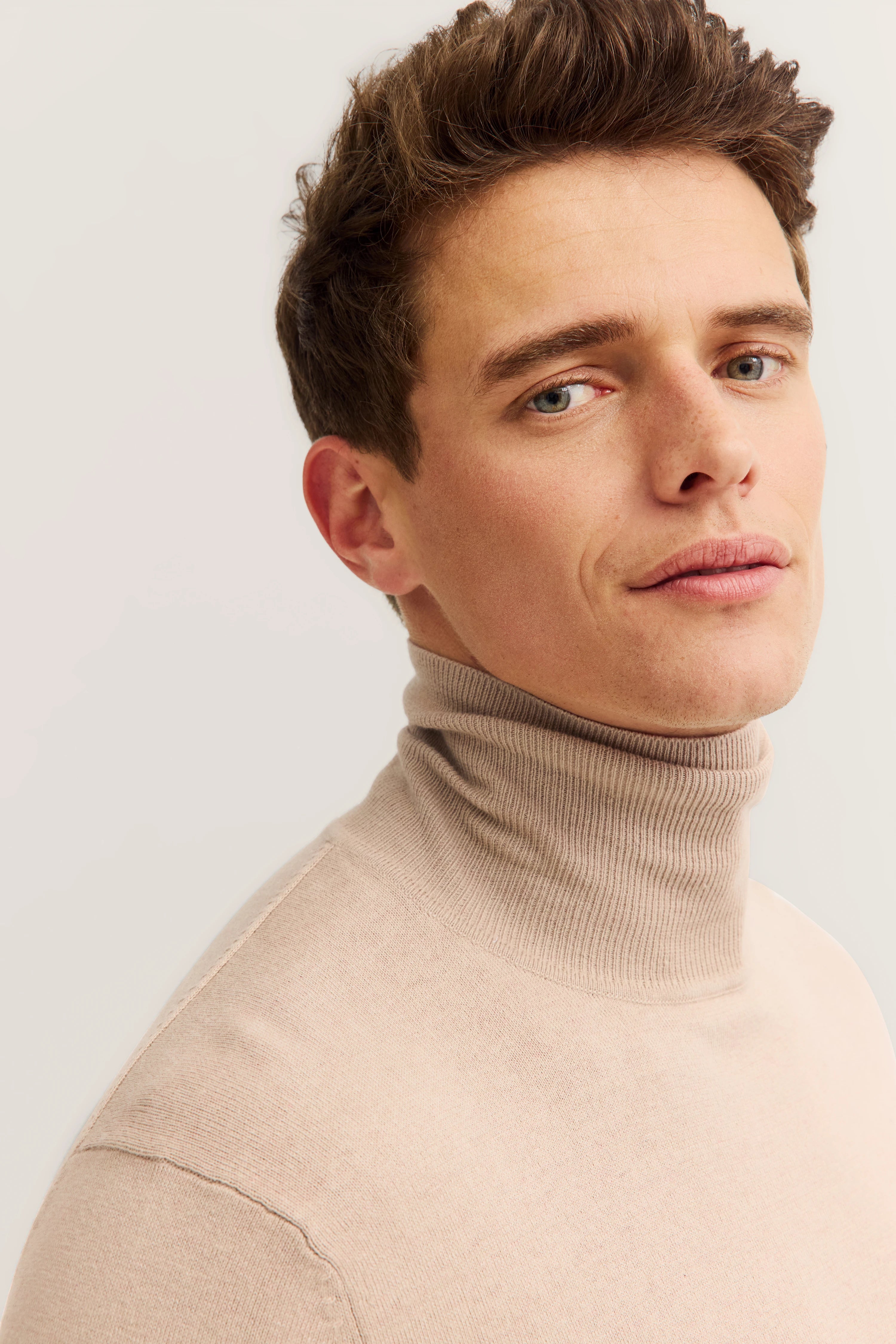 bugatti turtleneck sweater, beige, model posing relaxed, timeless elegance.