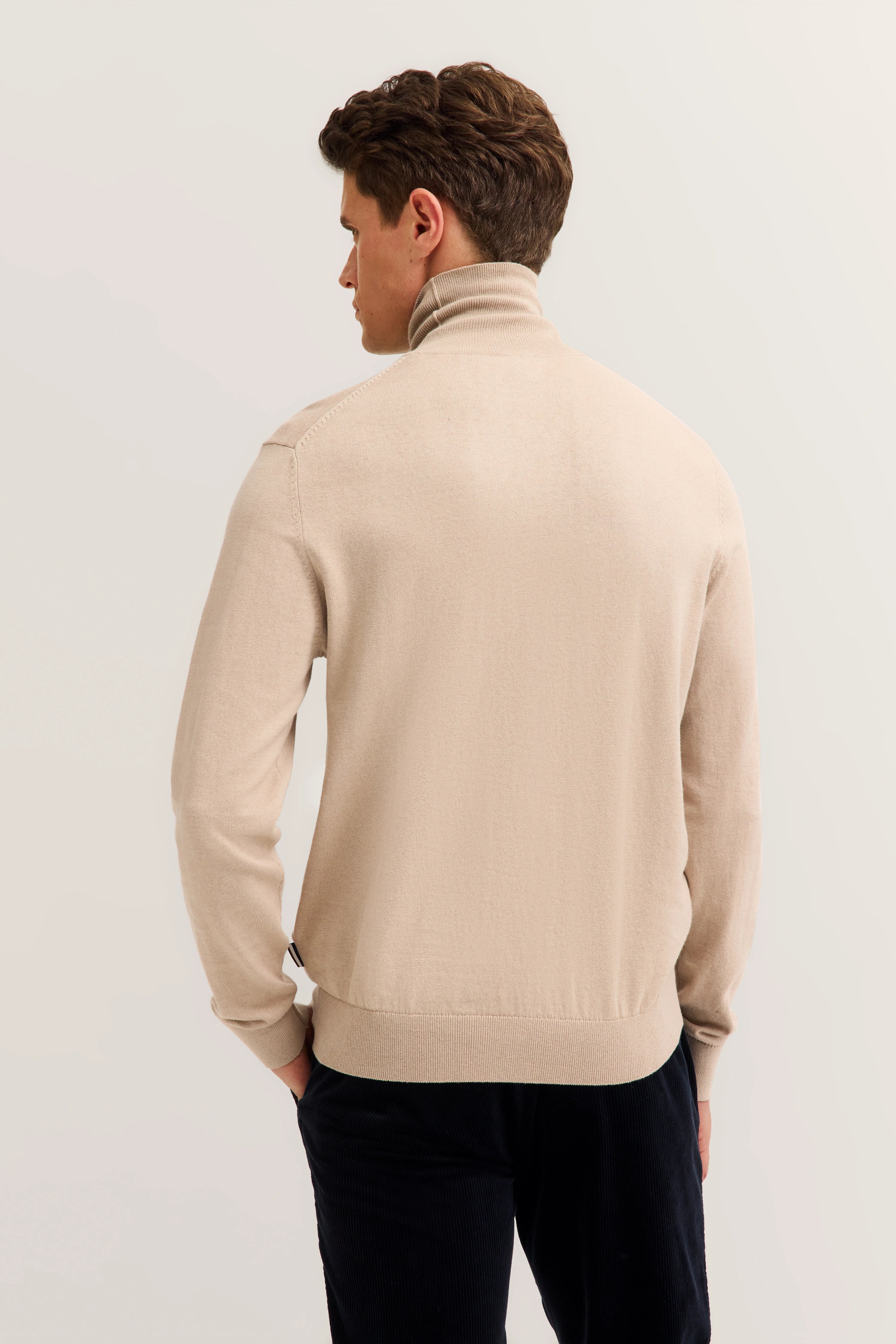 Beige turtleneck sweater by bugatti, back view, relaxed pose.