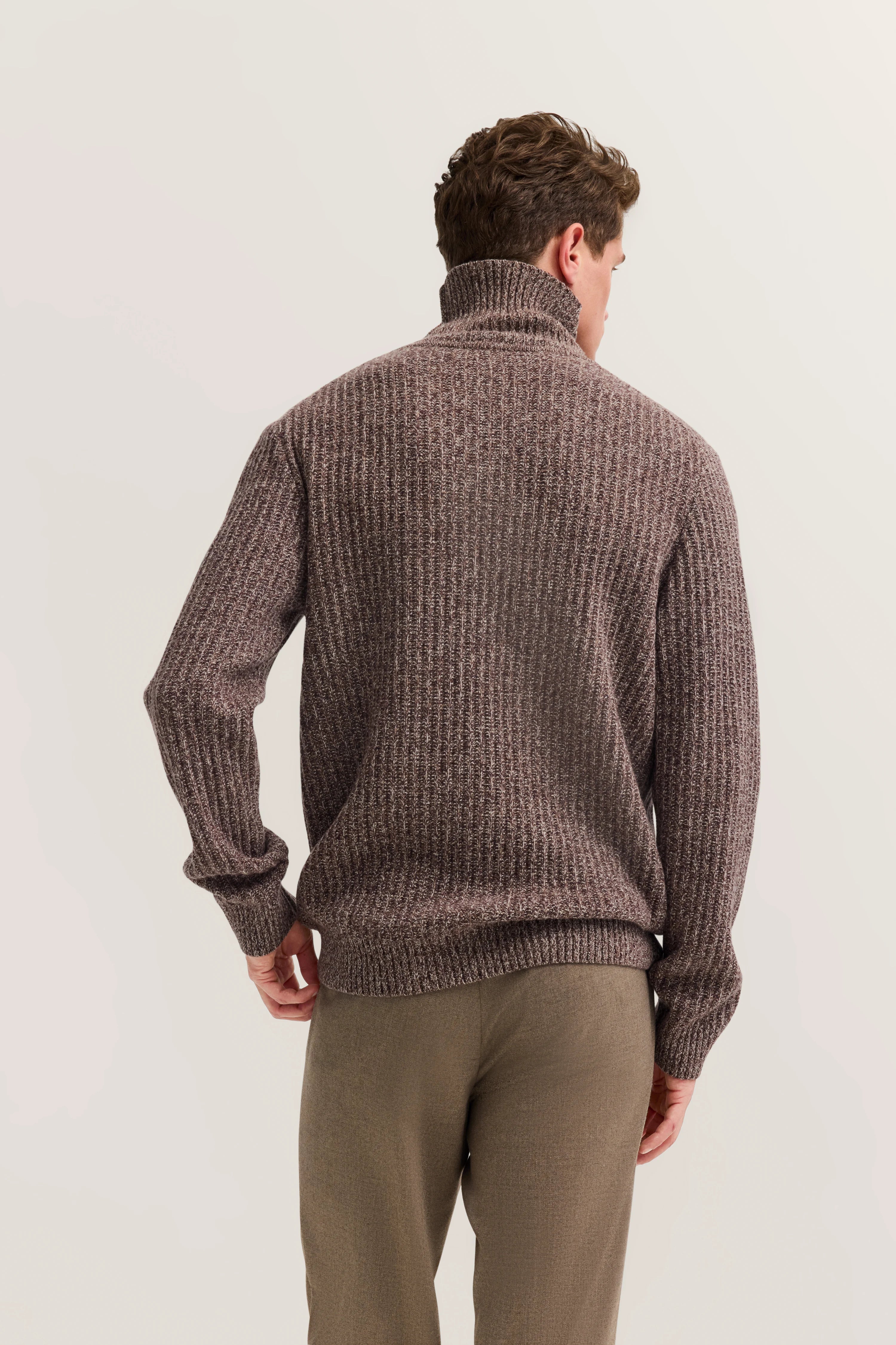 Brown turtleneck sweater by bugatti, back view on model, paired with beige trousers.