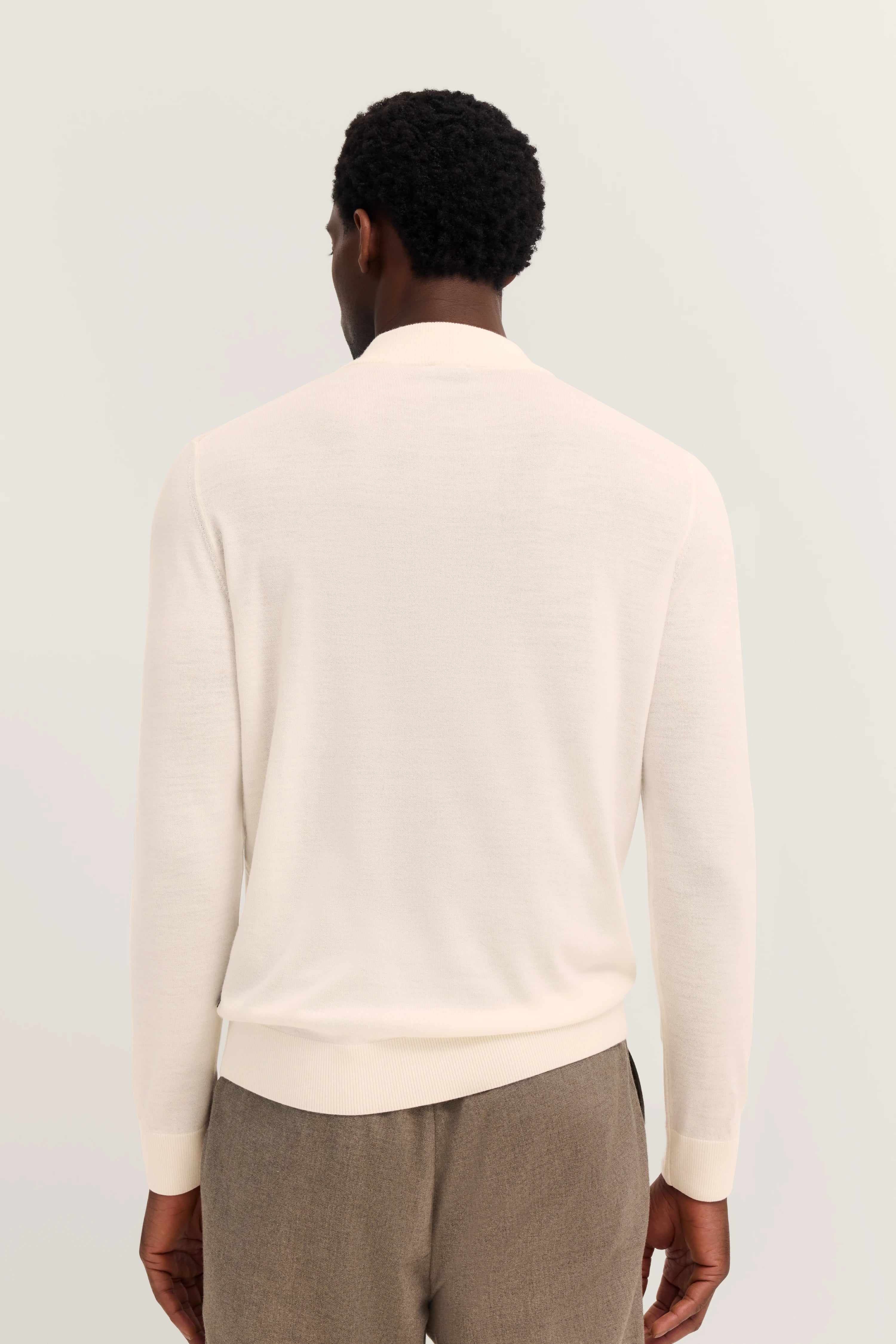 bugatti Beige Pullover Rückansicht auf Model mit brauner Hose, leger und stilvoll.