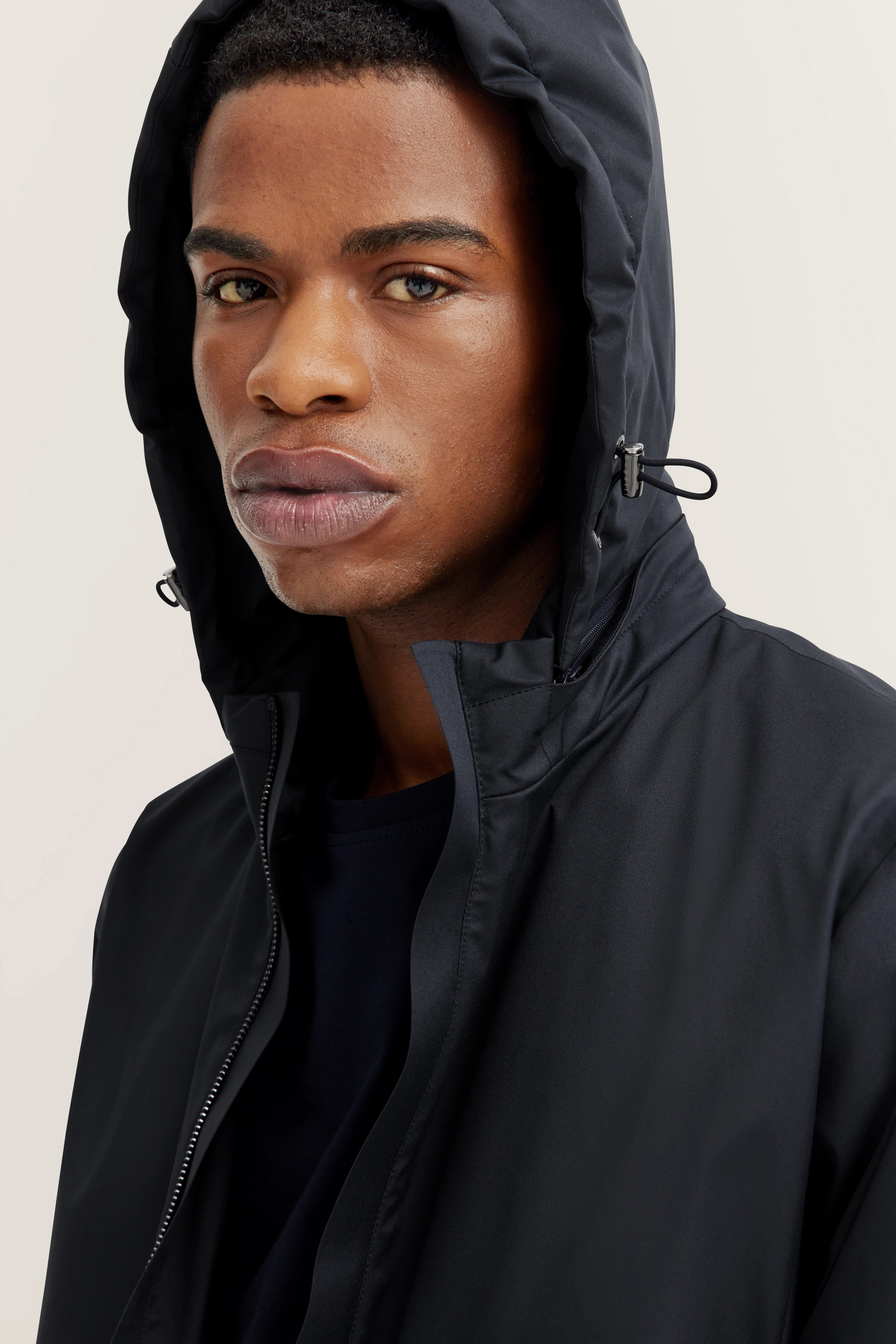 bugatti schwarze Jacke, Kapuze, Modelbild, nahes Gesicht, entspannter Blick.
