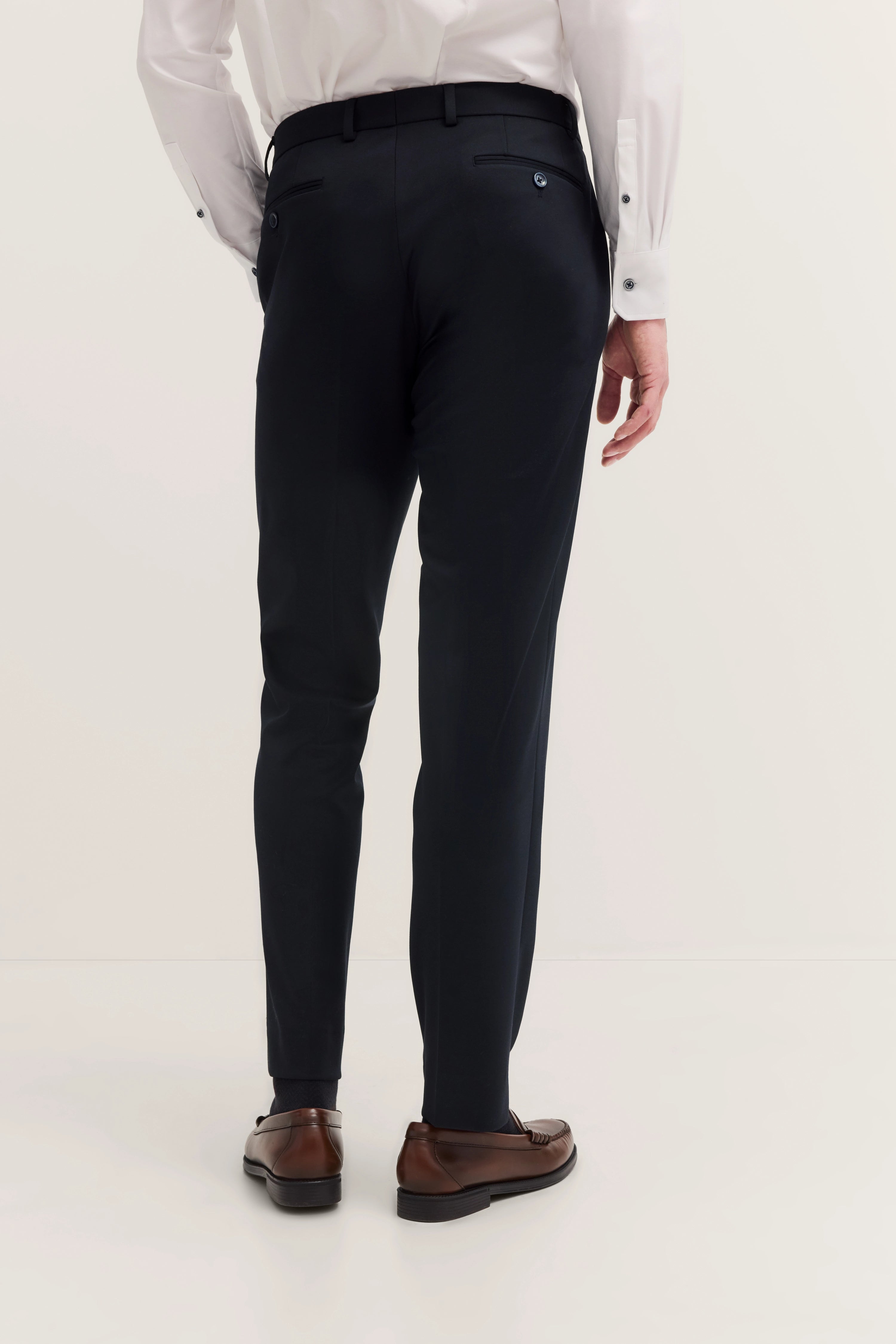 Büstenbild: Eleganter bugatti Anzughose in Dunkelblau mit weißem Hemd, braunen Lederschuhen, Rückansicht.