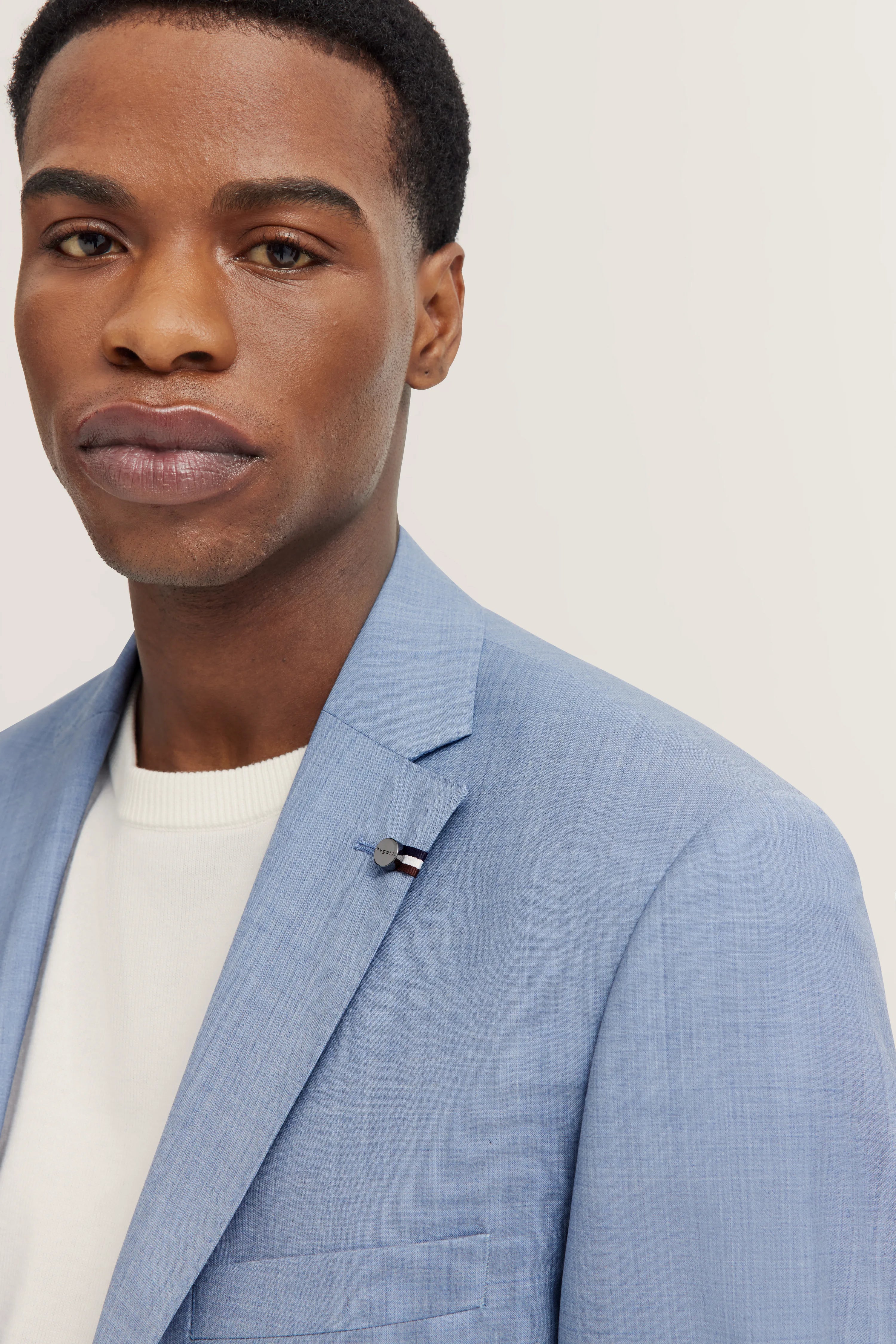 Blauw bugatti colbert, witte trui, buste, stijlvol en elegant.