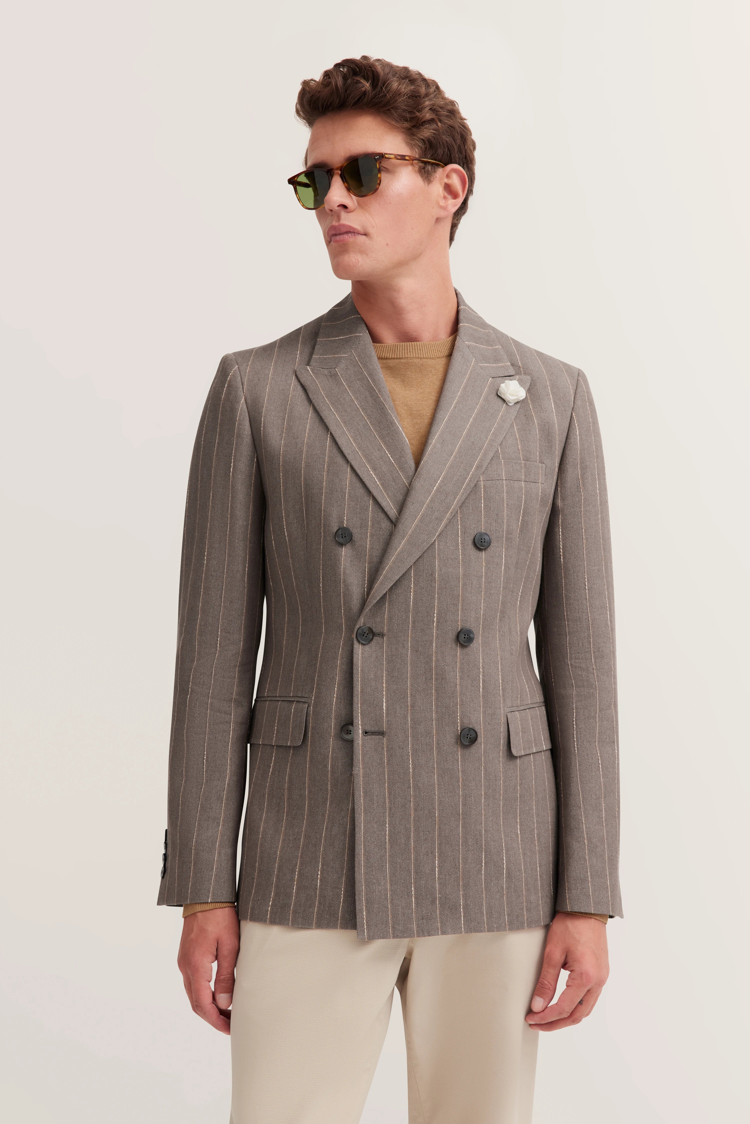 Grauer Nadelstreifenanzug, beiges Shirt, Büstenbild, klassisch-elegant.