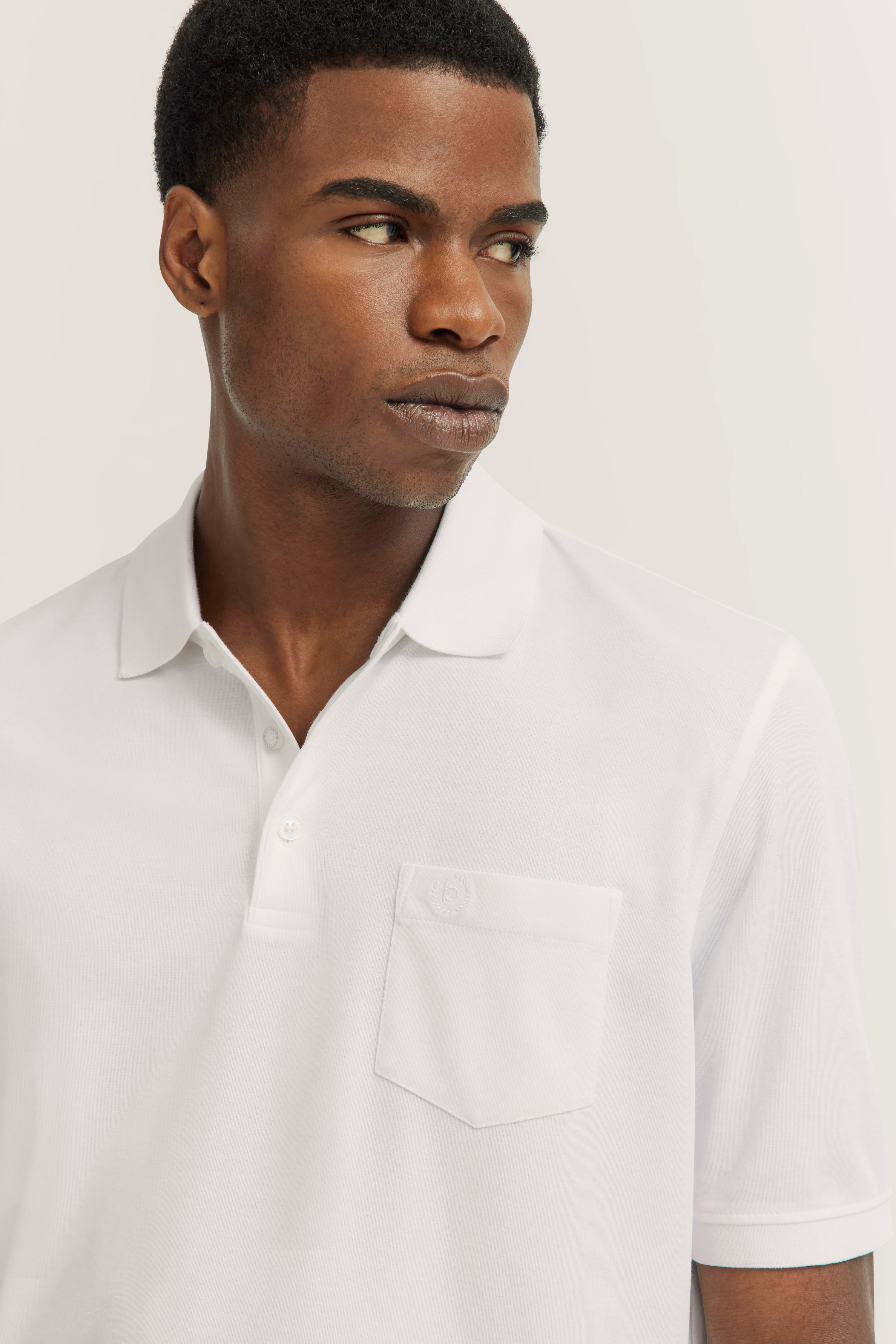 Weißes bugatti Poloshirt, Modelbild, Mann im Profil, hochwertig und zeitlos elegant.