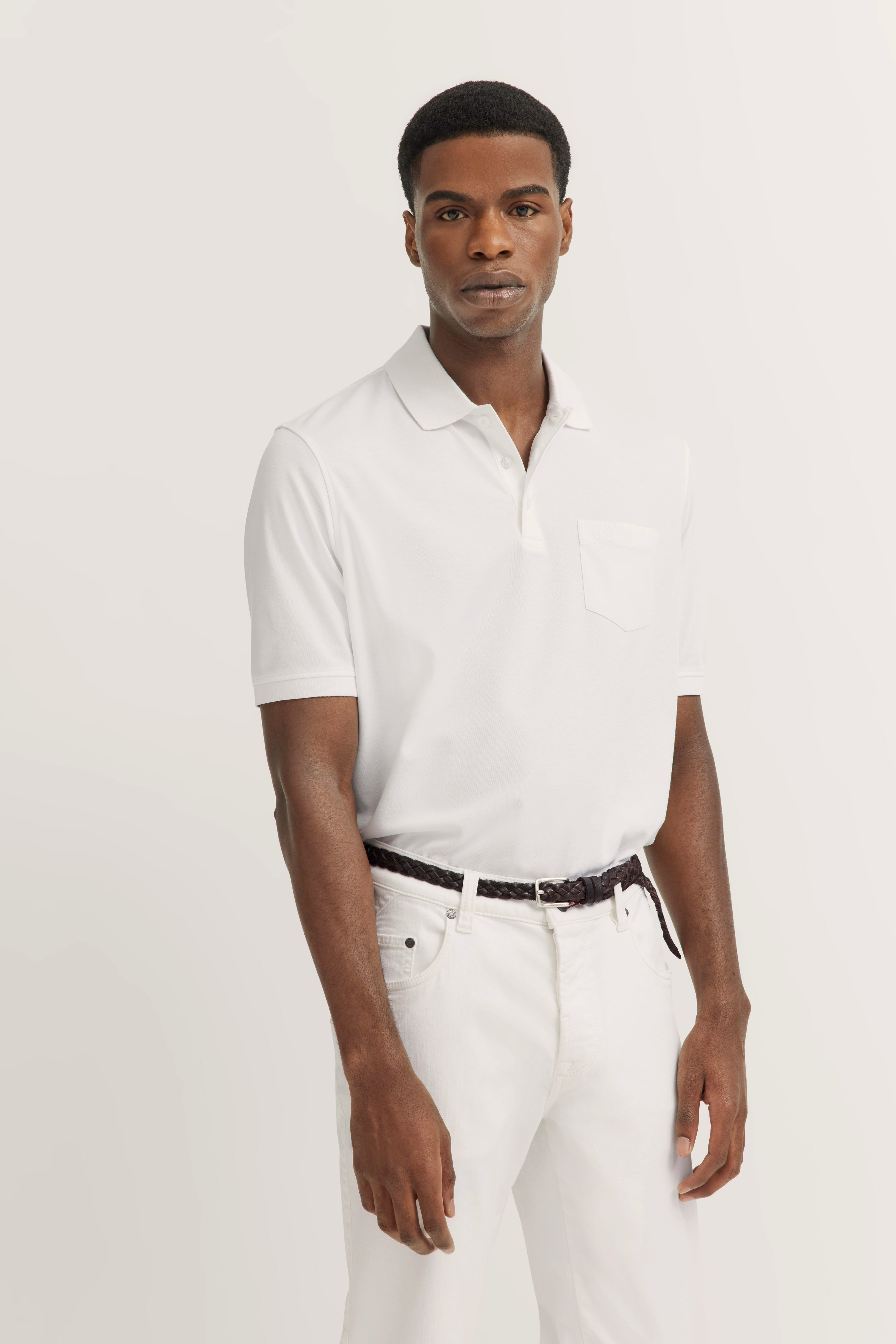 White bugatti polo and pants, casual model shot, relaxed pose.