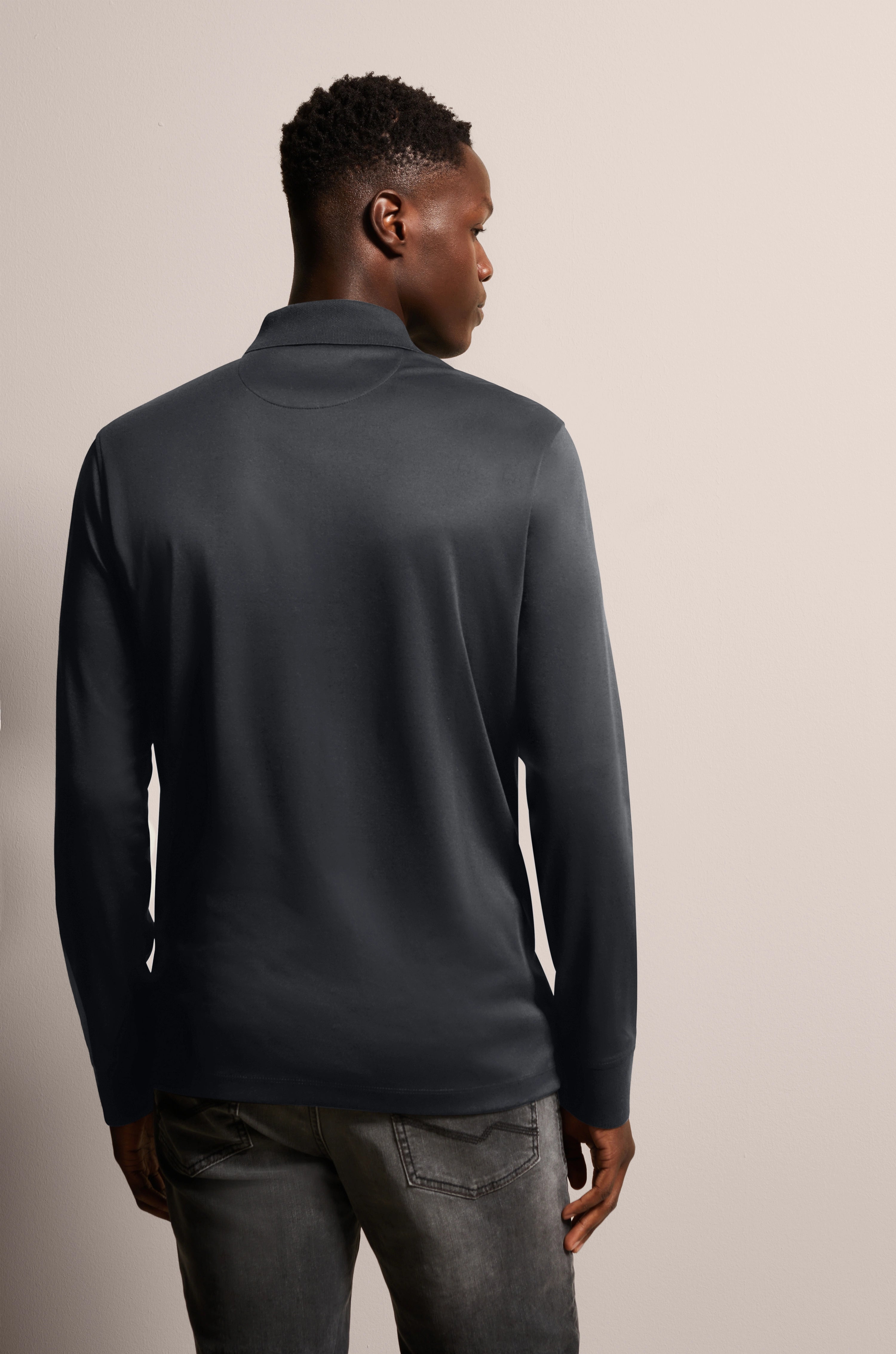 Black bugatti long-sleeve shirt, back view, casually worn with grey jeans.