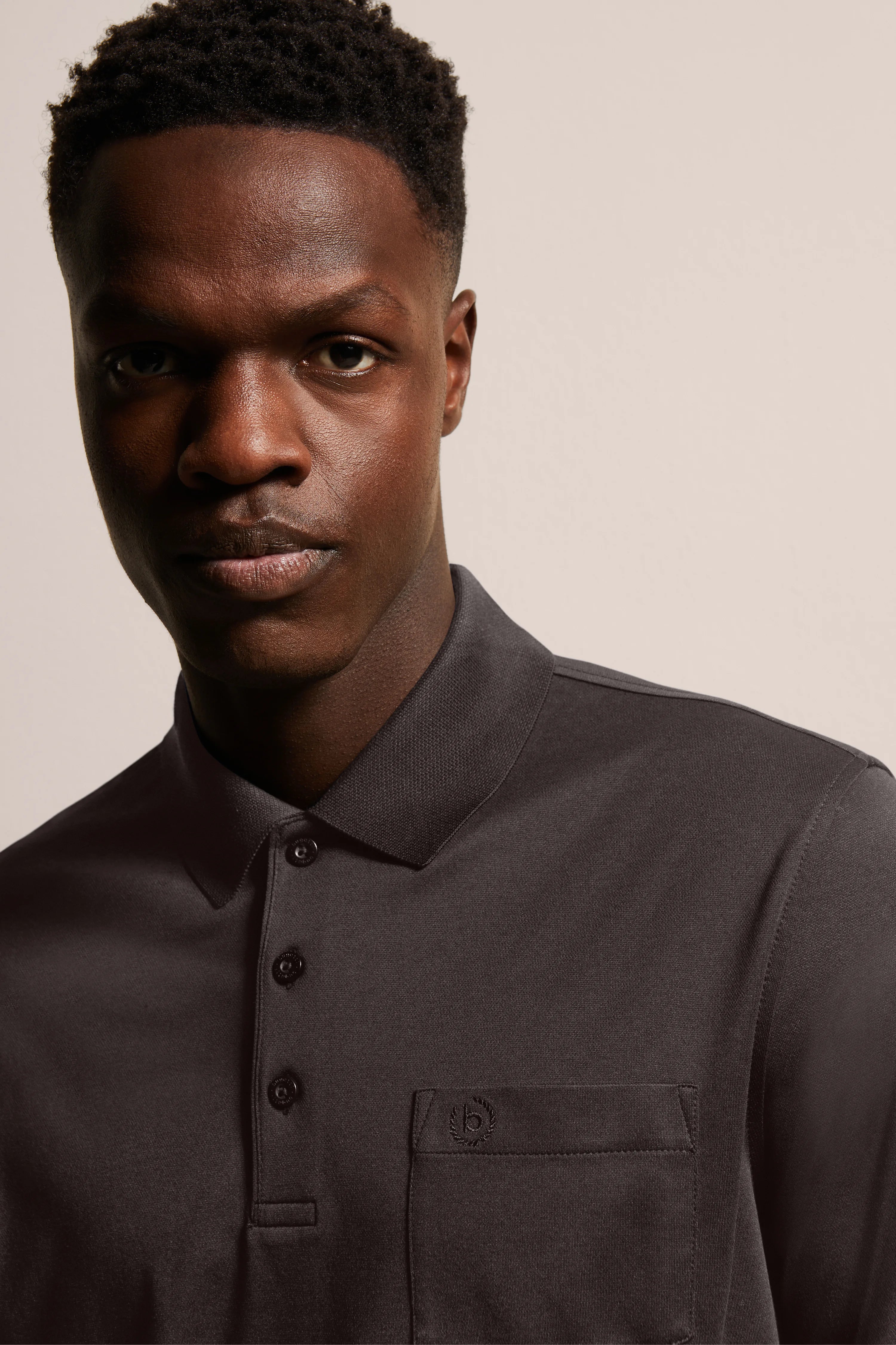 Man in dark grey bugatti polo shirt with button placket and chest pocket.