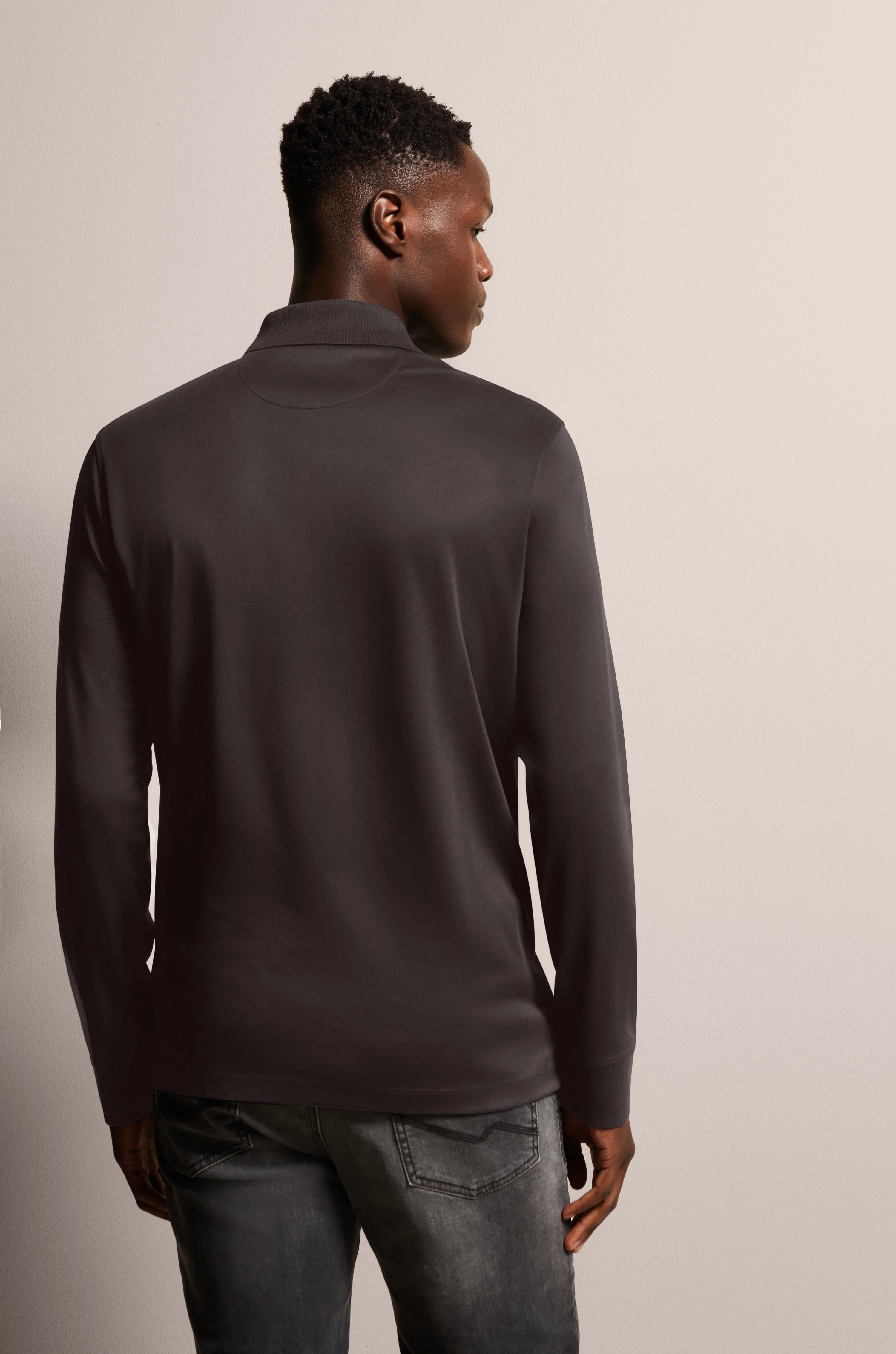 Black bugatti long-sleeve shirt, model from behind, relaxed pose.