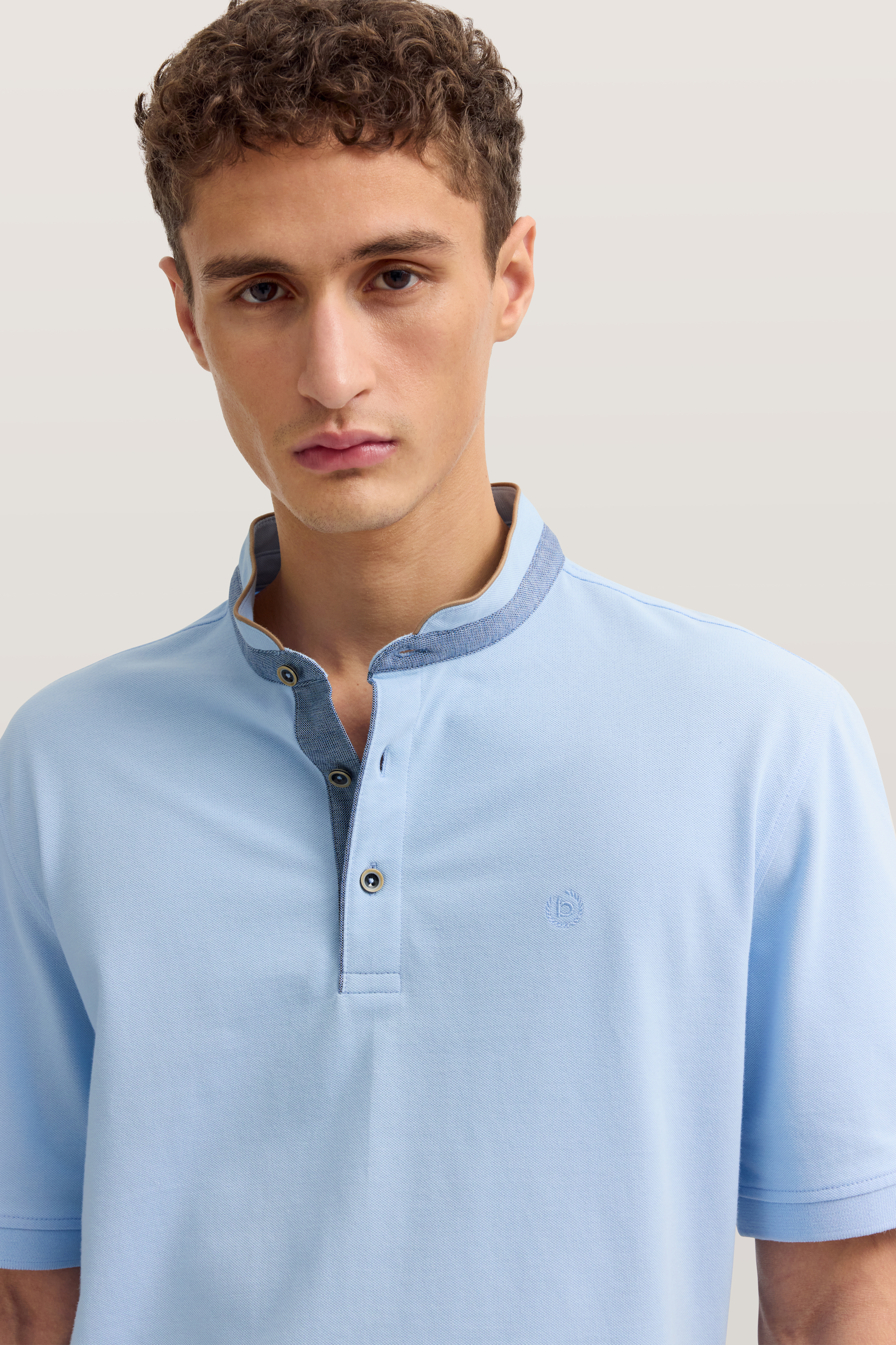 Büstenbild eines Mannes im hellblauen bugatti Poloshirt mit Kontrastkragen.