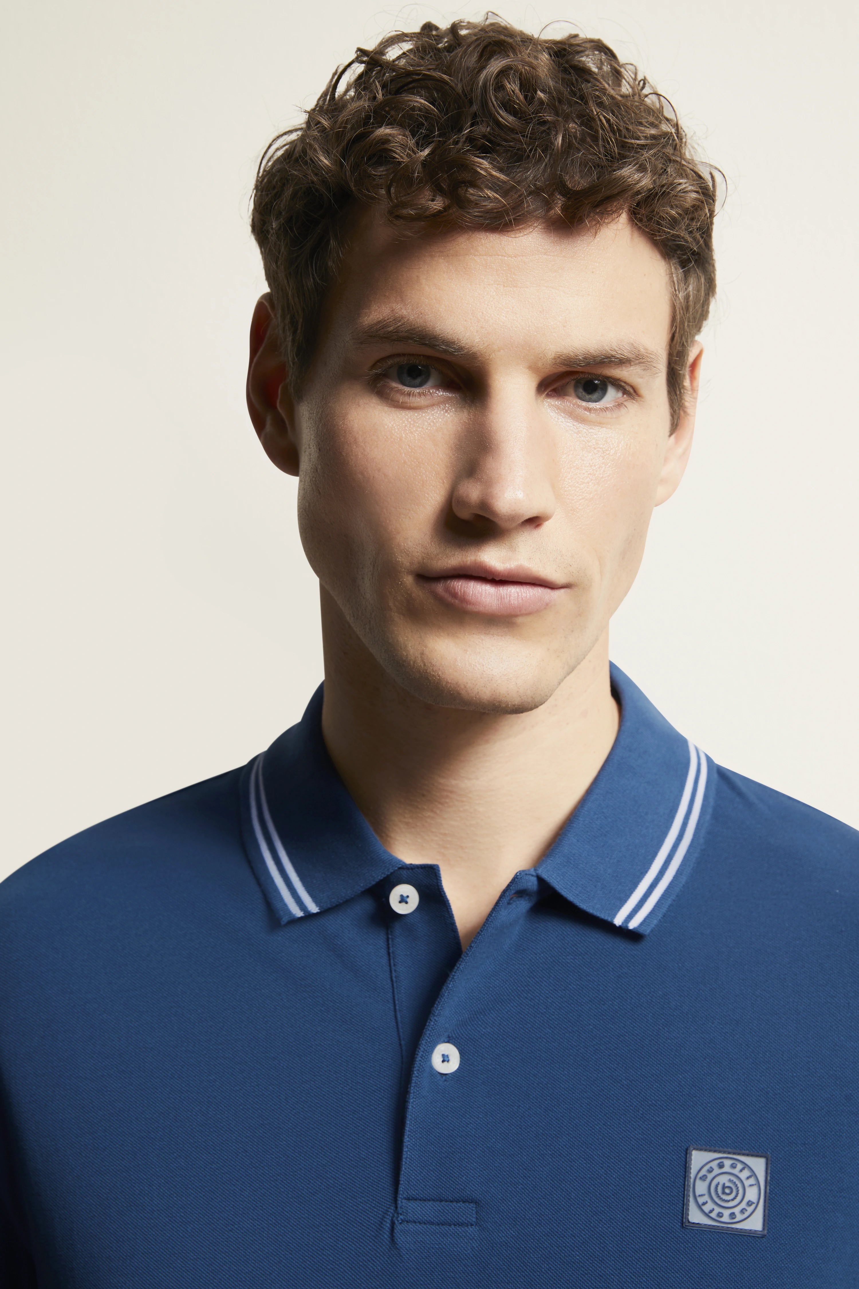 bugatti blue polo shirt, casual pose, stylish and refined look.