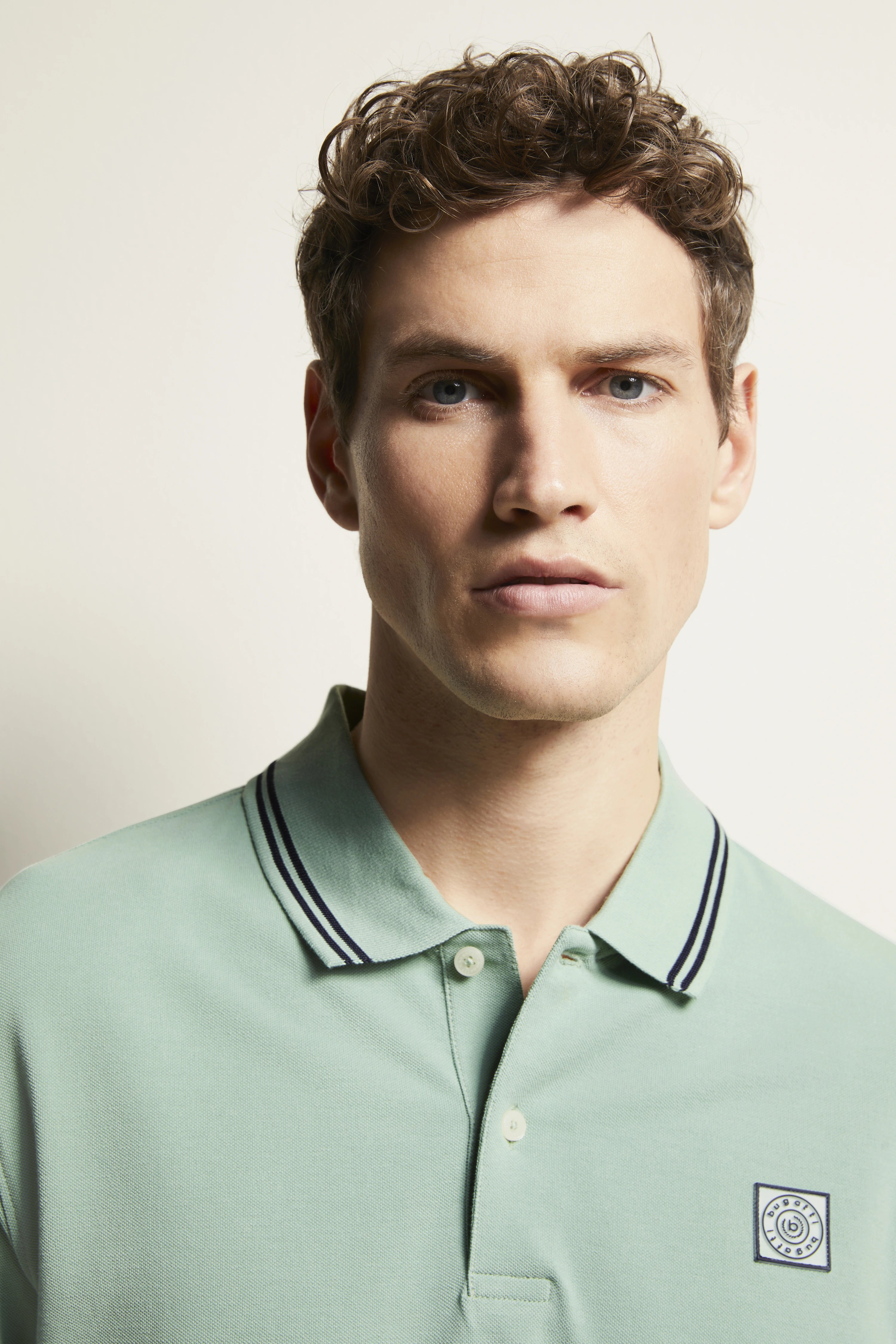 bugatti mint green polo shirt with contrast stripes, model image, neutral expression.