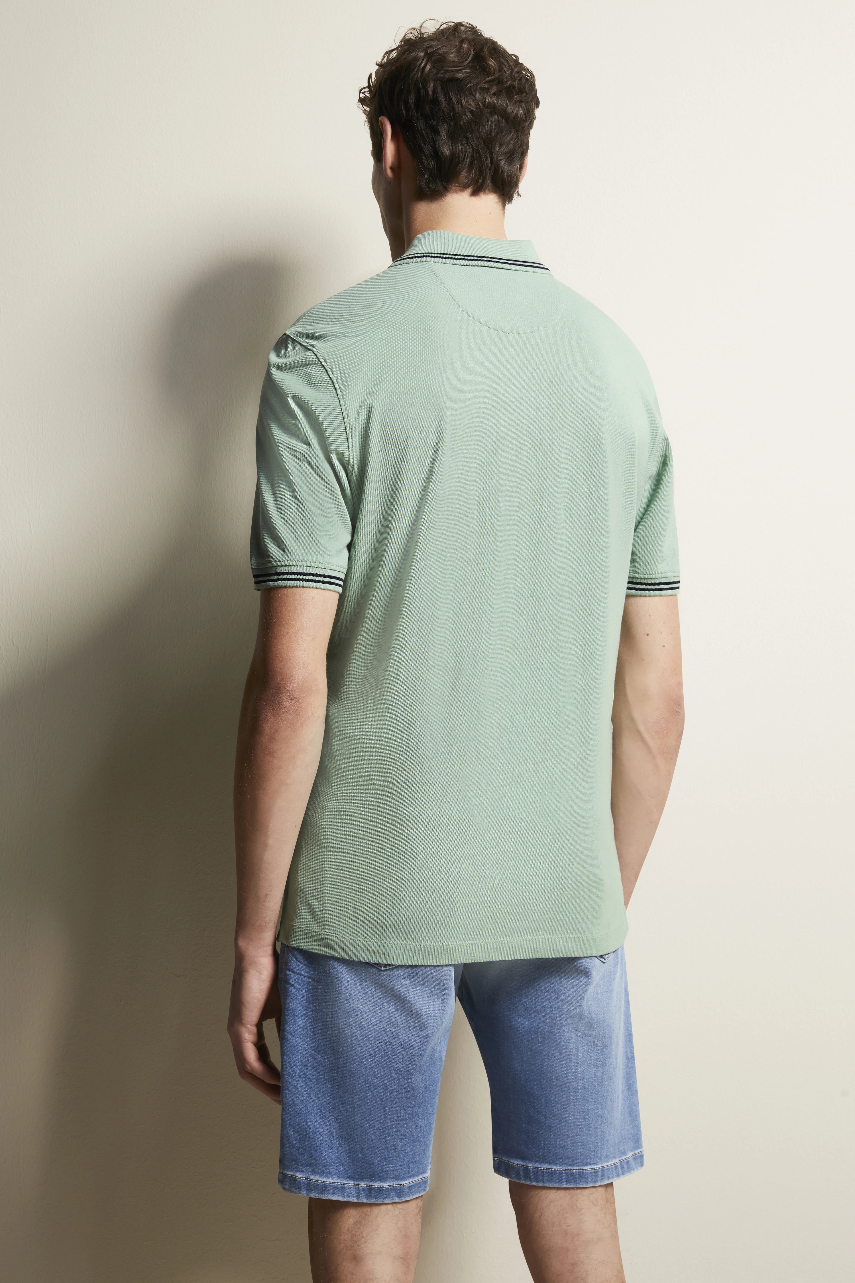 bugatti model: green polo shirt, blue denim shorts, back view, relaxed stance.