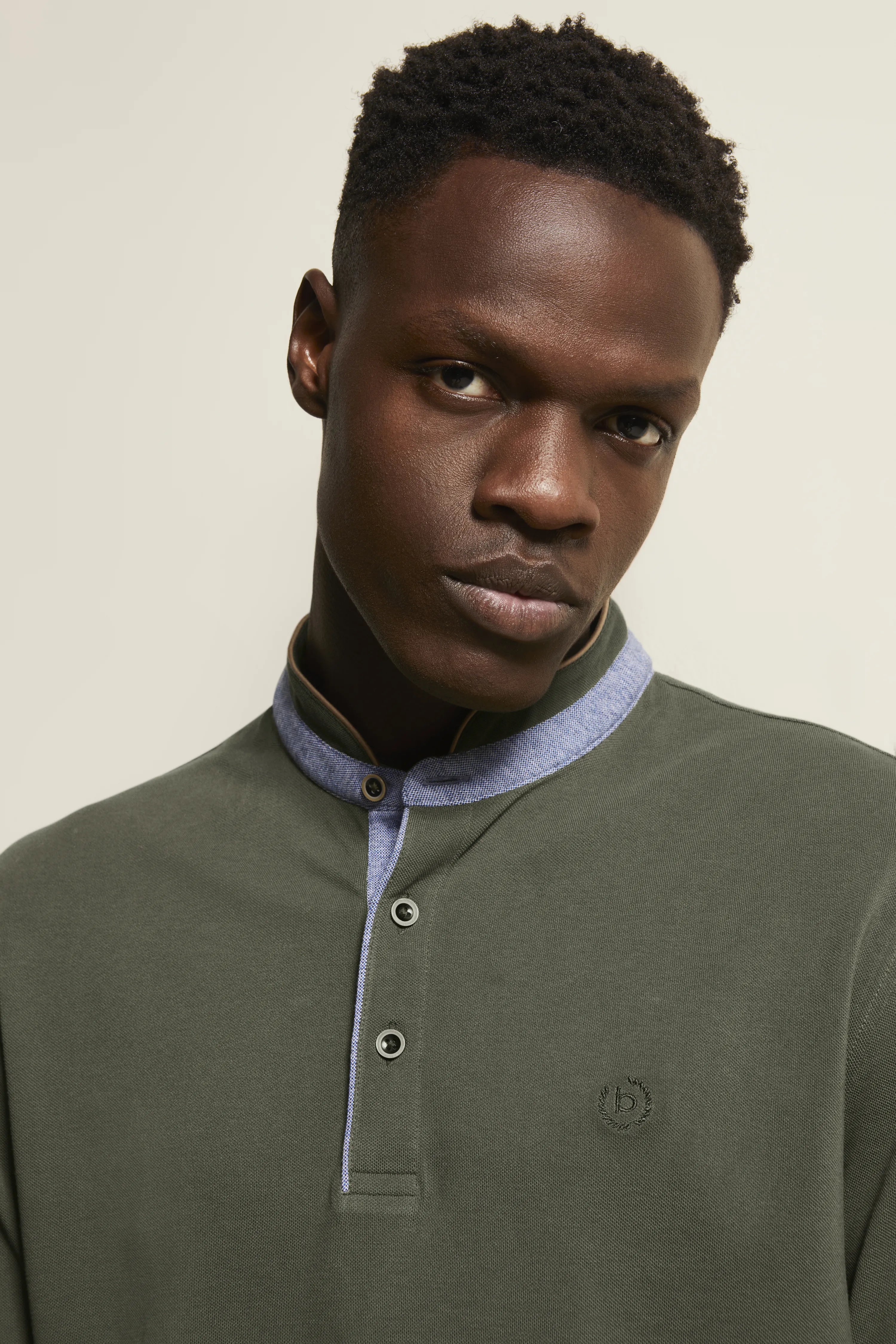 Büstenbild eines Mannes im olivgrünen bugatti Shirt mit blauem Kragen und Knopfleiste.