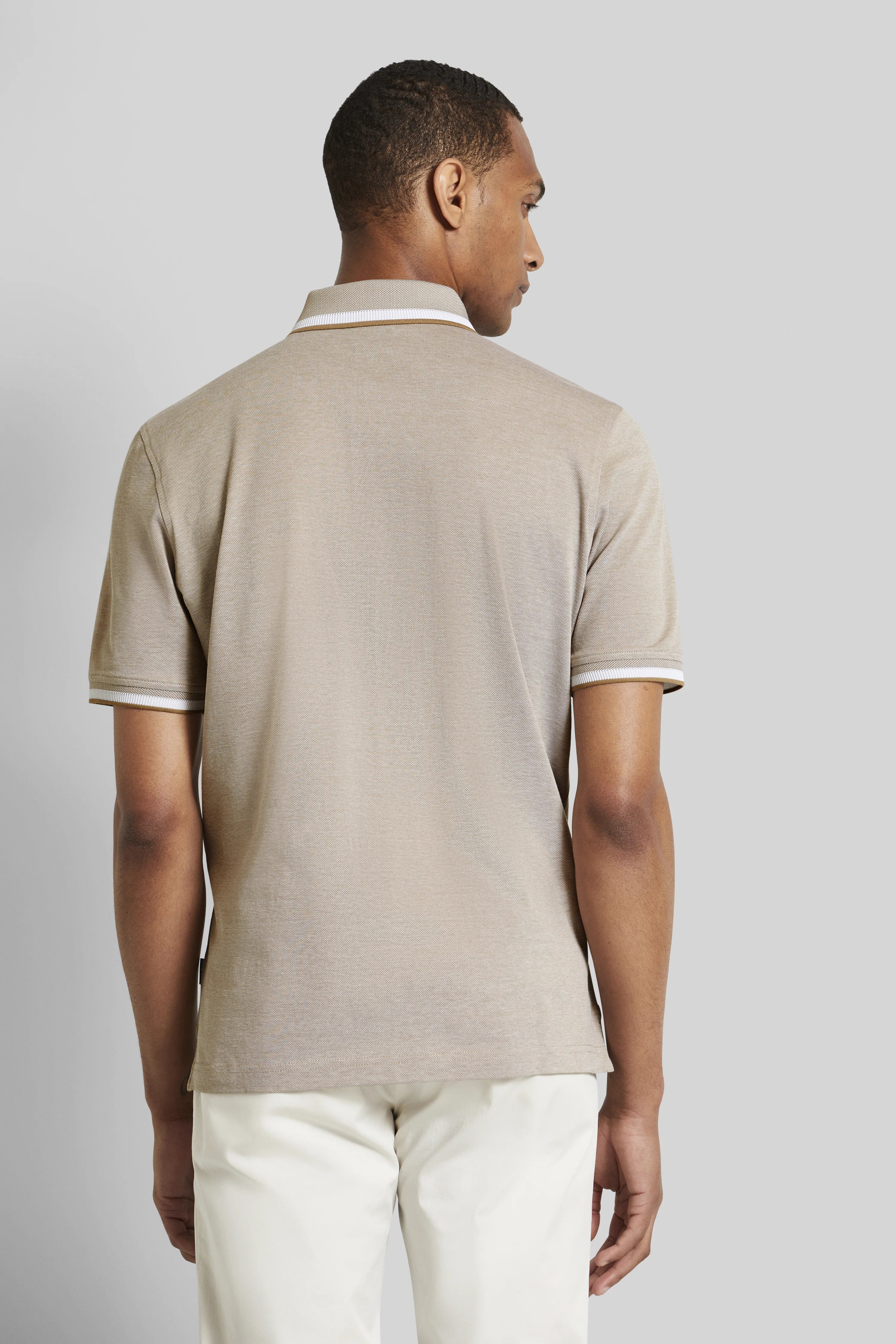 Beiges Polo-Shirt und weiße Hose von bugatti, Model von hinten, entspannte Haltung.