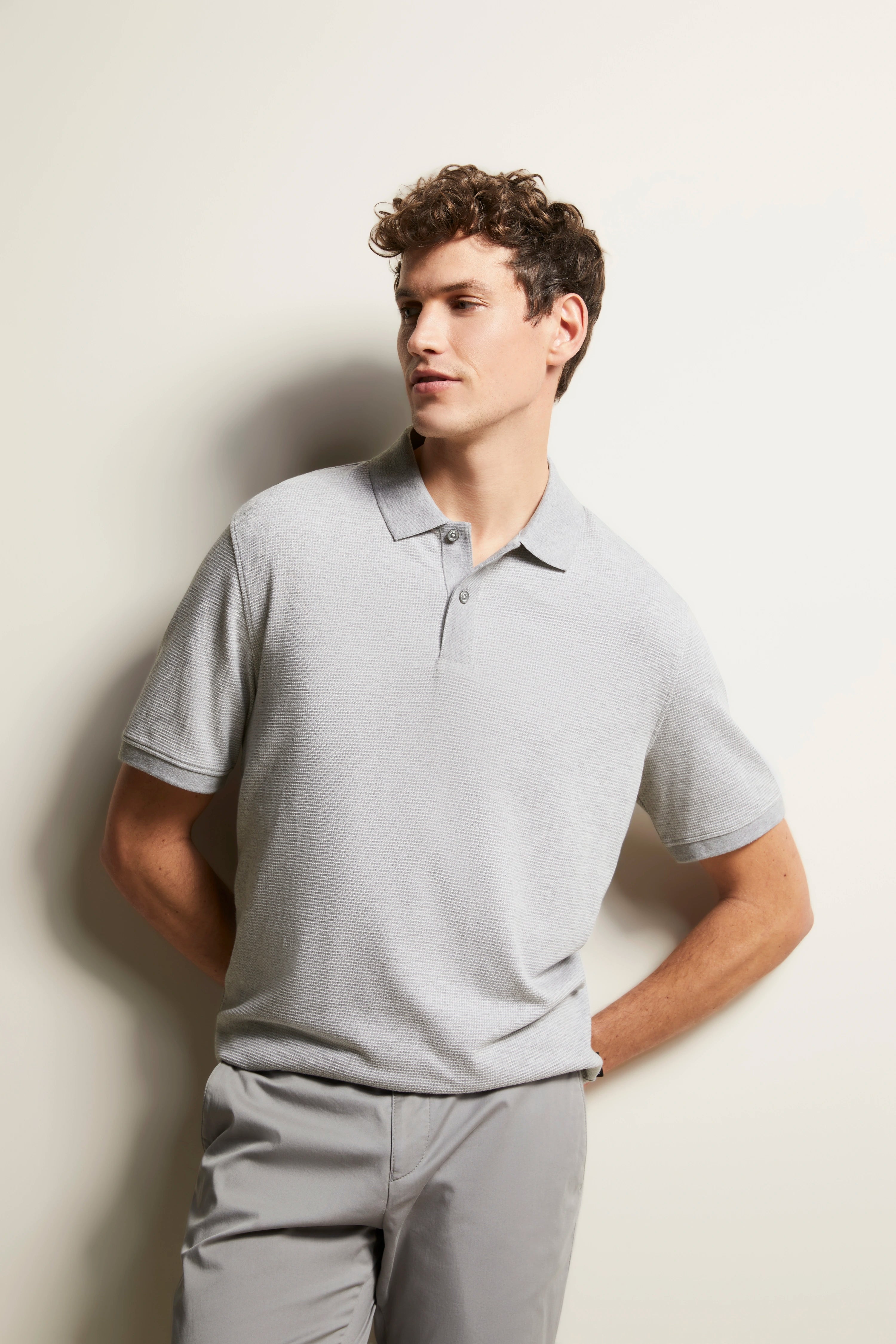 Graues Polohemd und Hose von bugatti, Modellbild, entspannte Pose, zeitloser Stil.