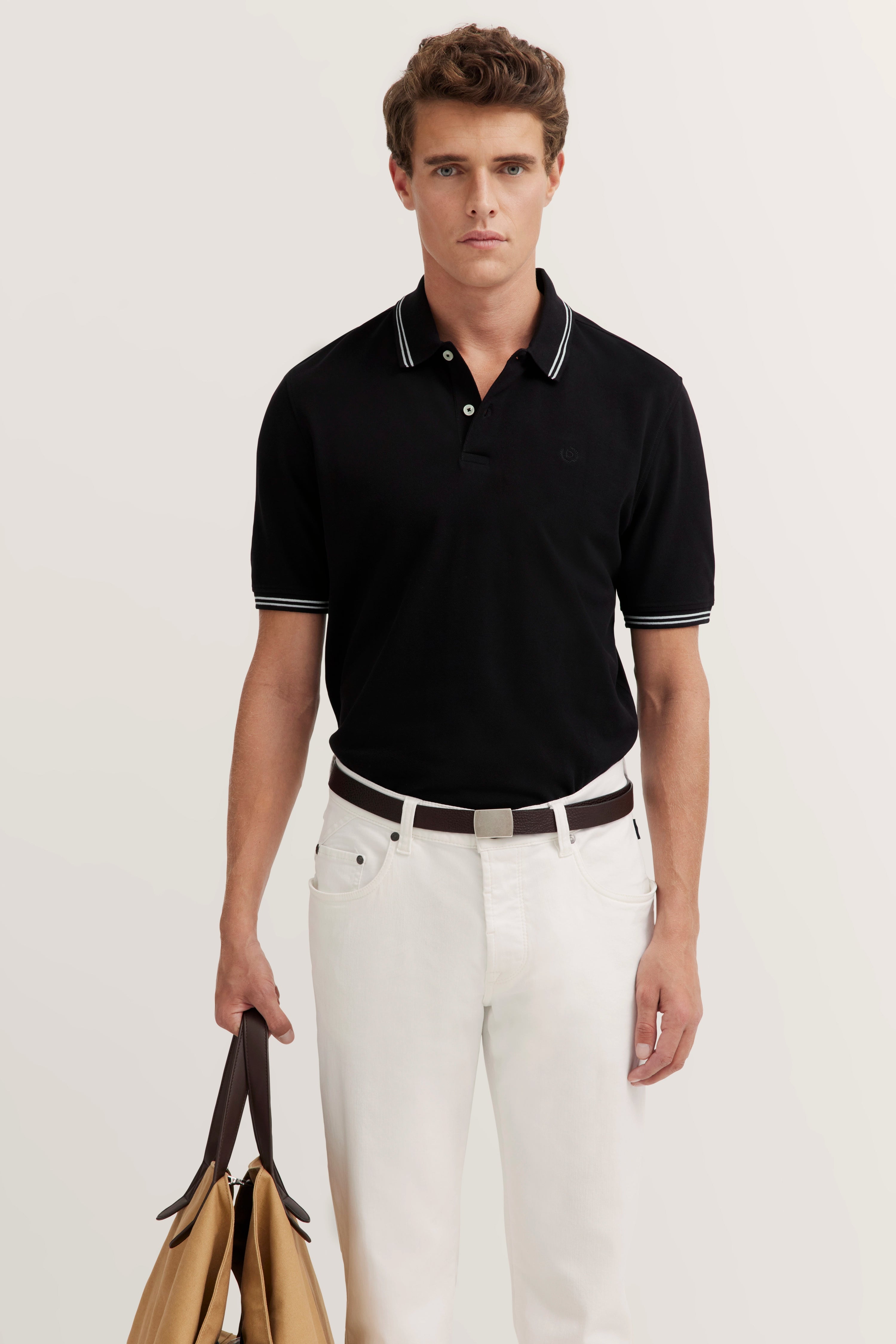 Zwart bugatti poloshirt, witte broek, casual model, natuurlijke pose.