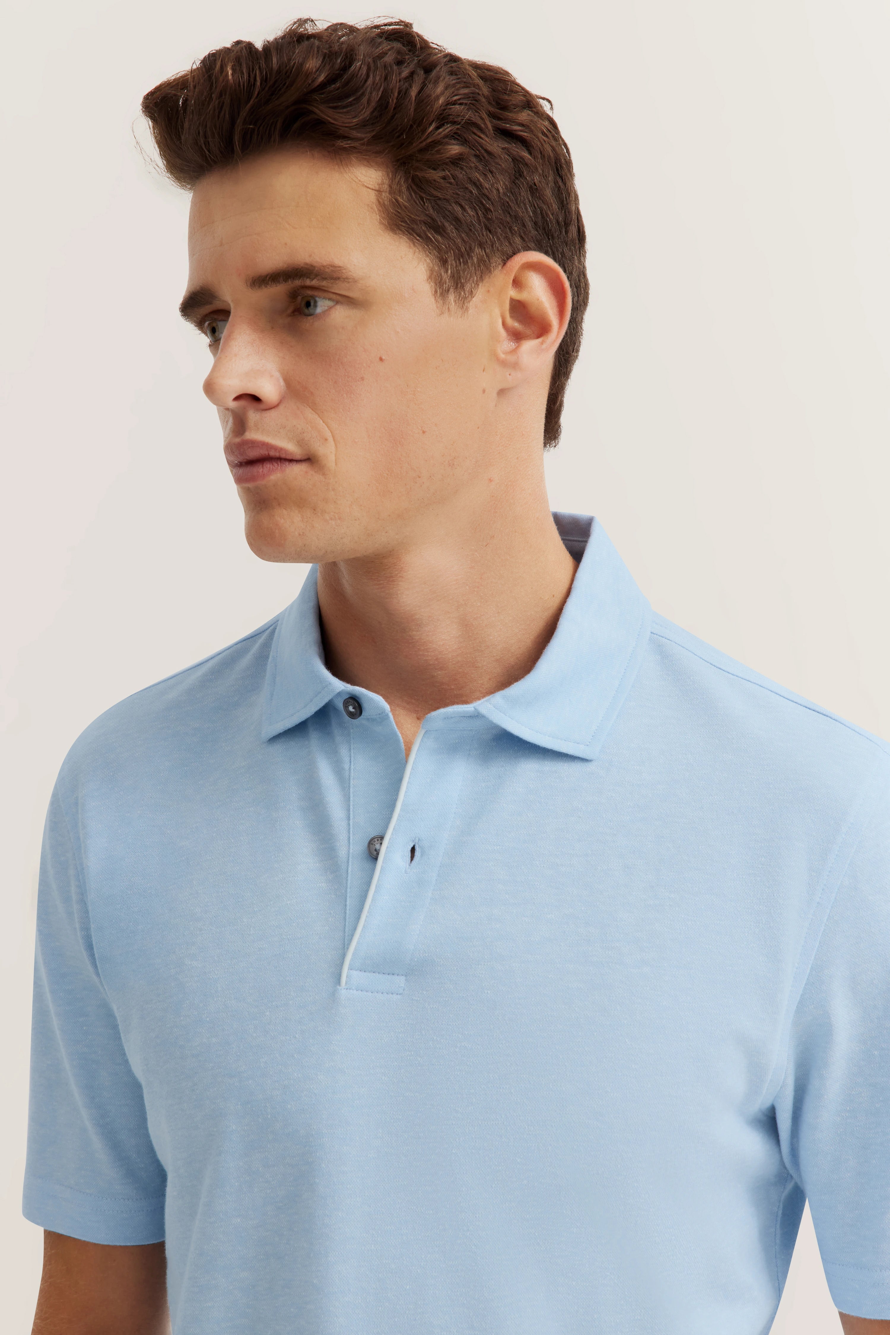 Blue polo shirt, model posing casually, bugatti style and elegance.