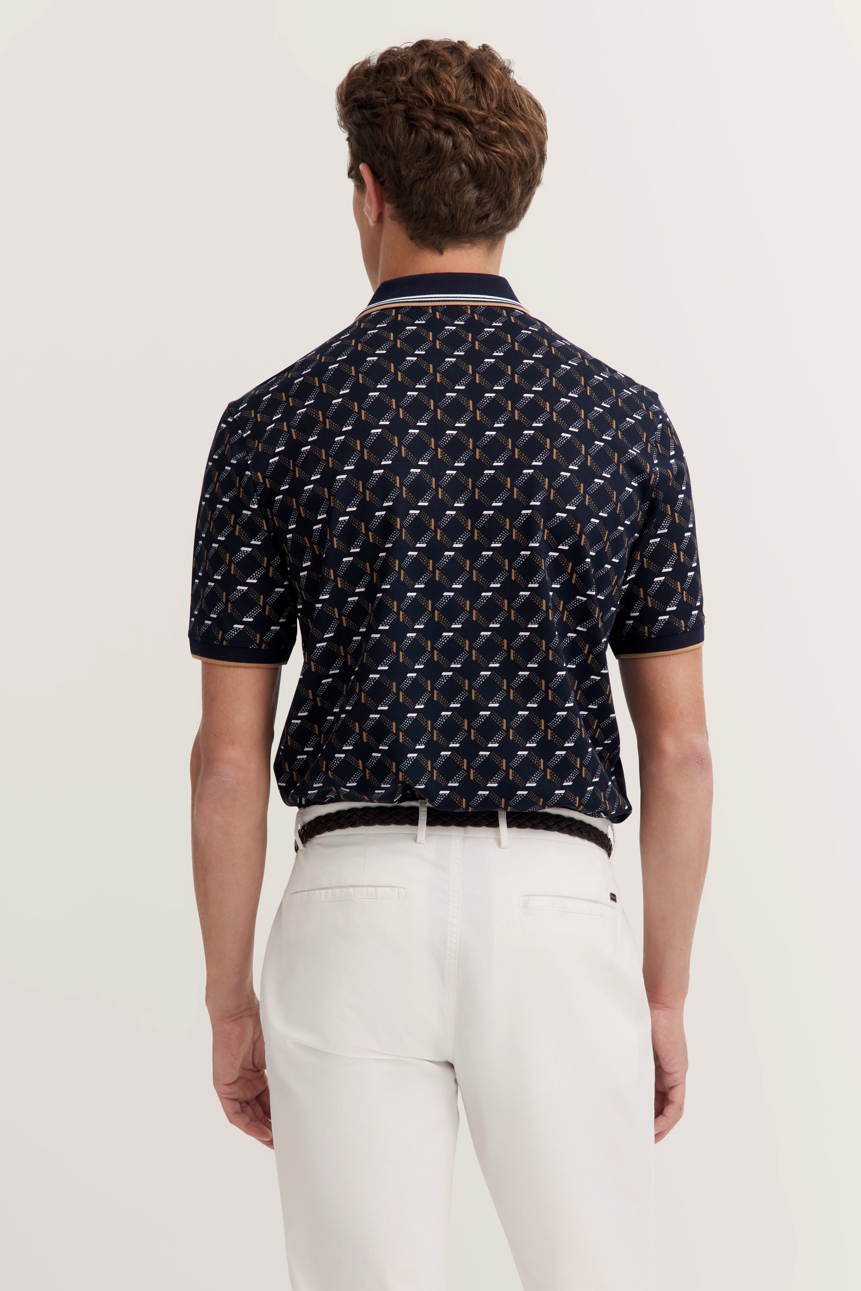 Back view: Dark patterned shirt, white pants. Model stands relaxed. Stylish with bugatti.