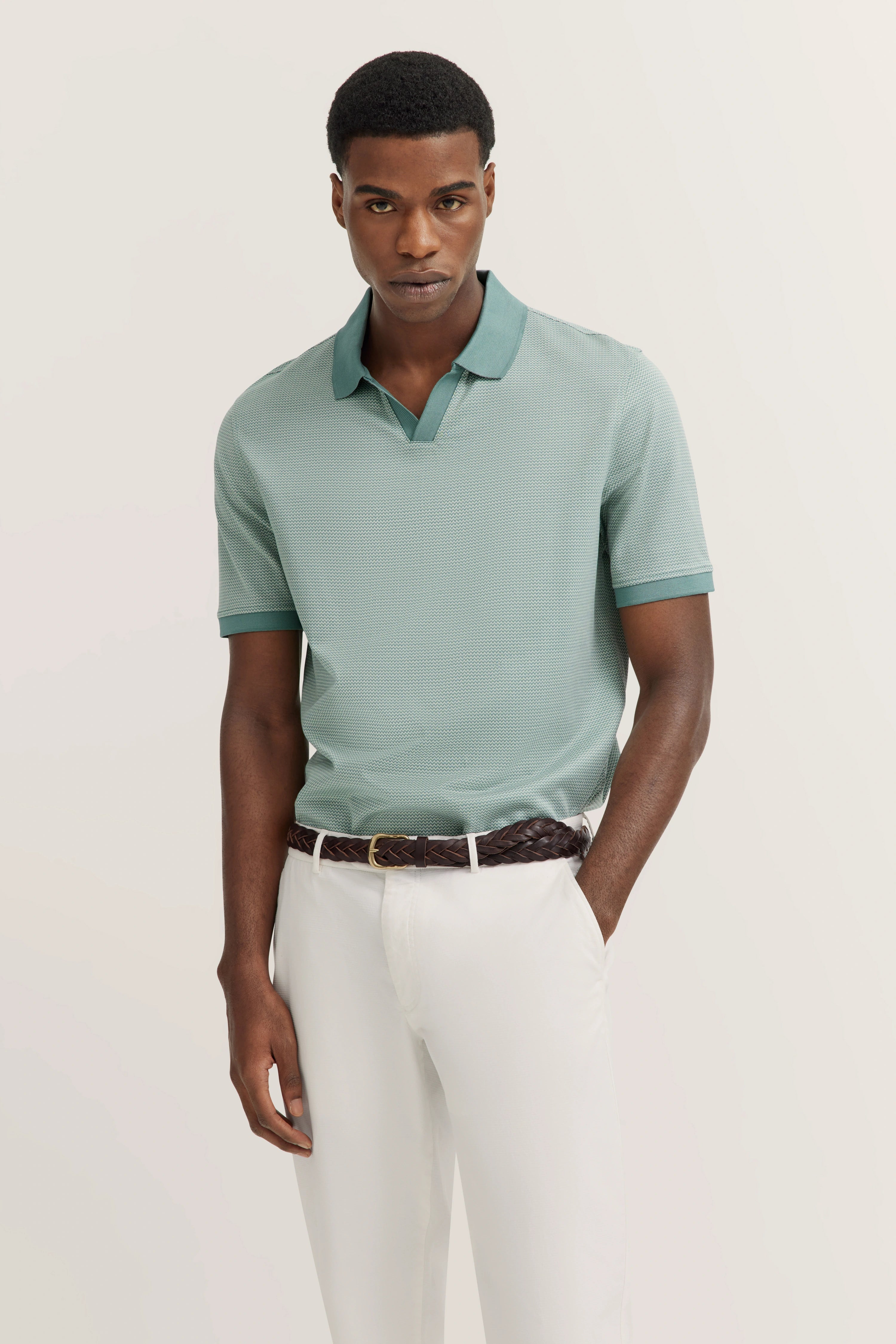 Mint green polo shirt, white pants, bust image, casually and stylishly presented.
