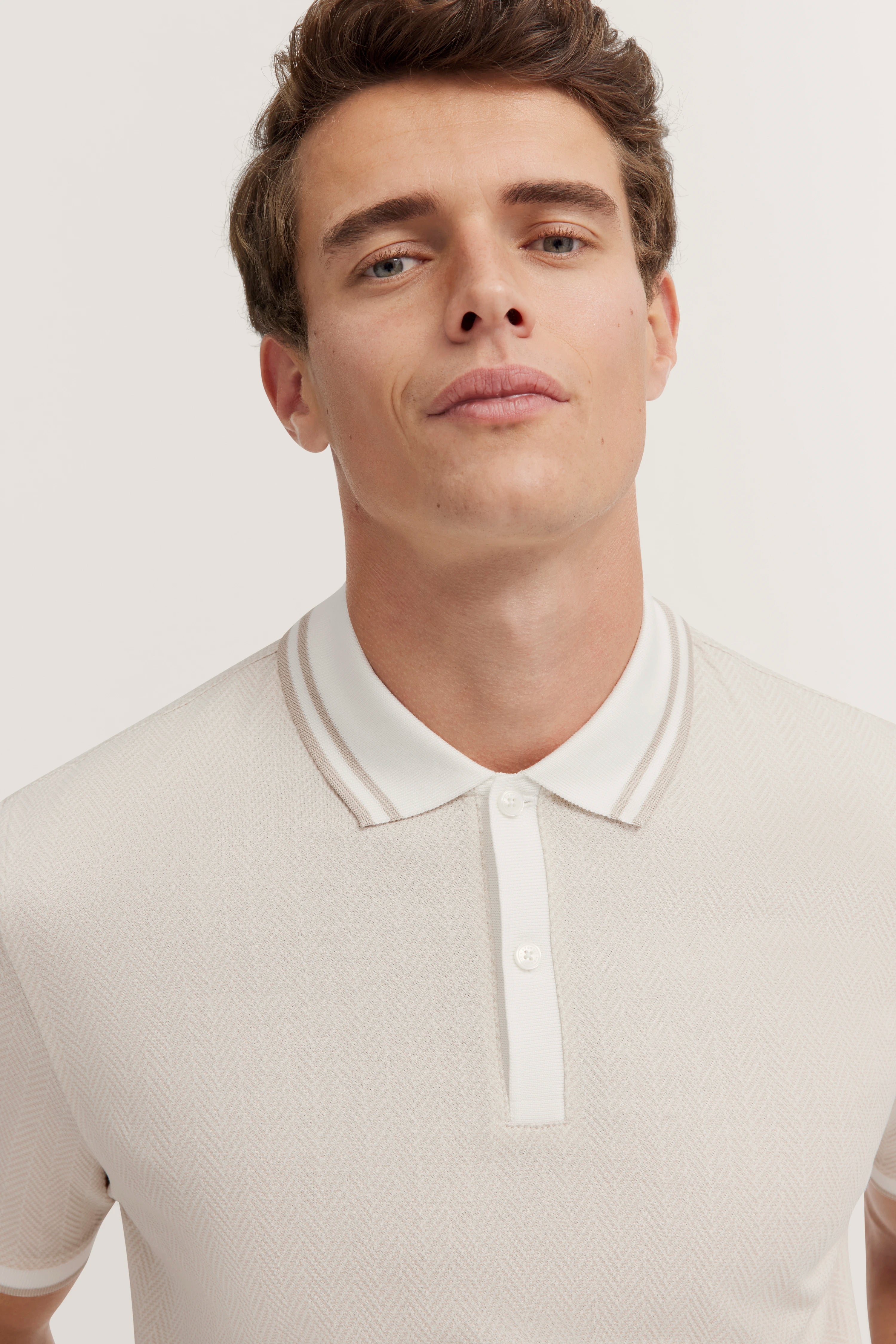 bugatti model image: White polo with subtle pattern, casual collar, confident pose.