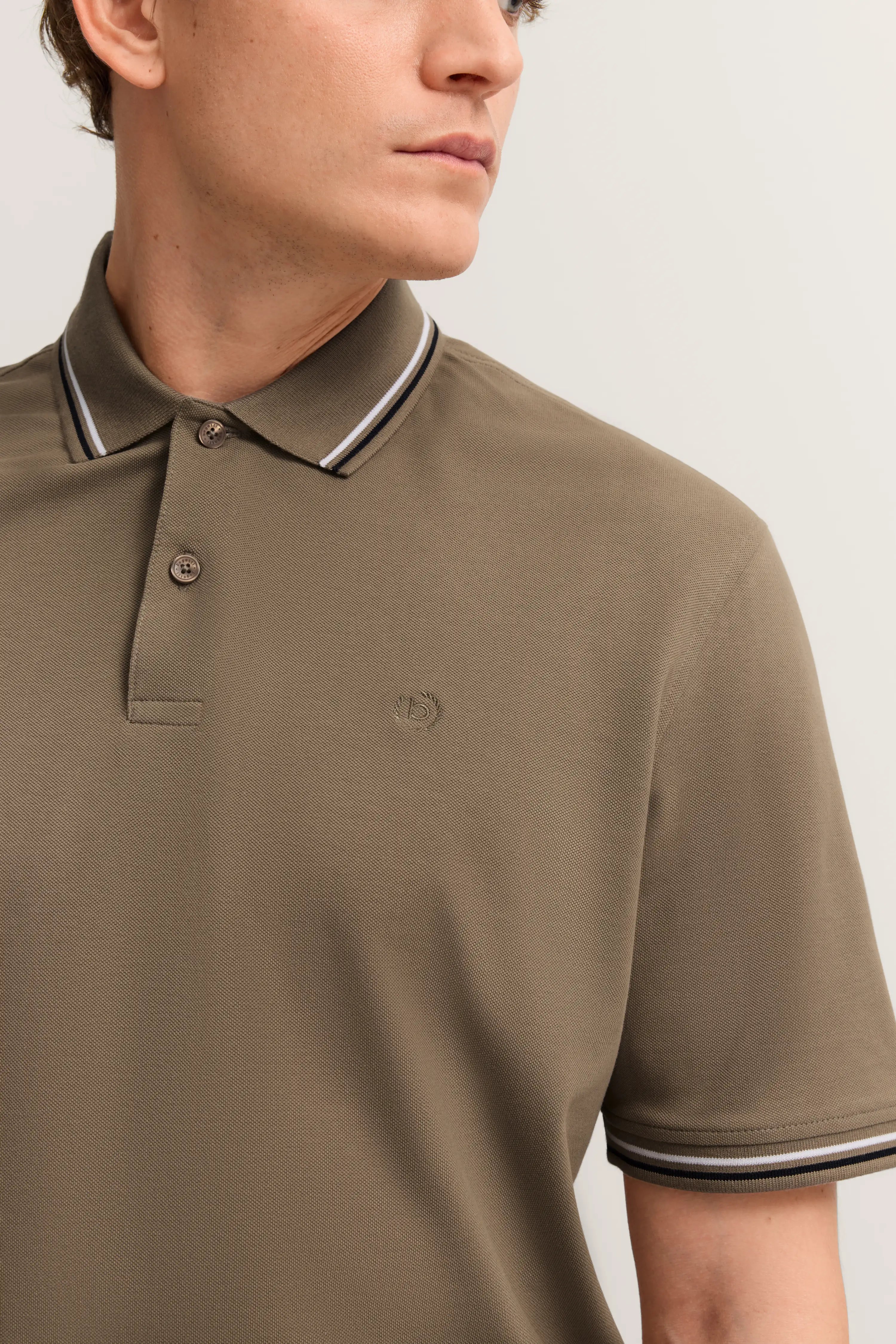 Büstenbild eines bugatti Poloshirts in Olivgrün mit Streifen am Kragen.