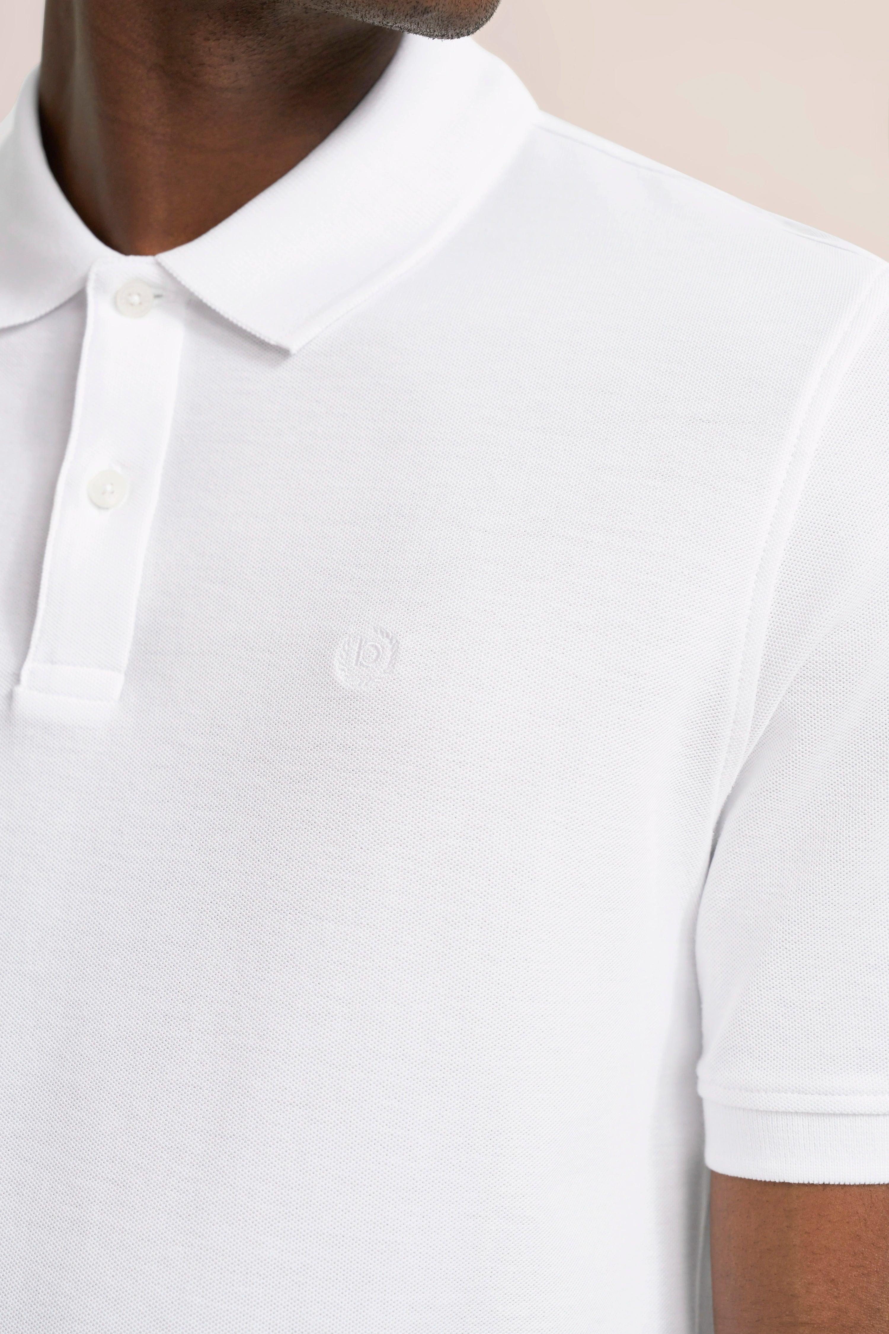 Weißes bugatti Poloshirt, Nahaufnahme, Büstenbild, klassischer Stil und schlichte Eleganz.