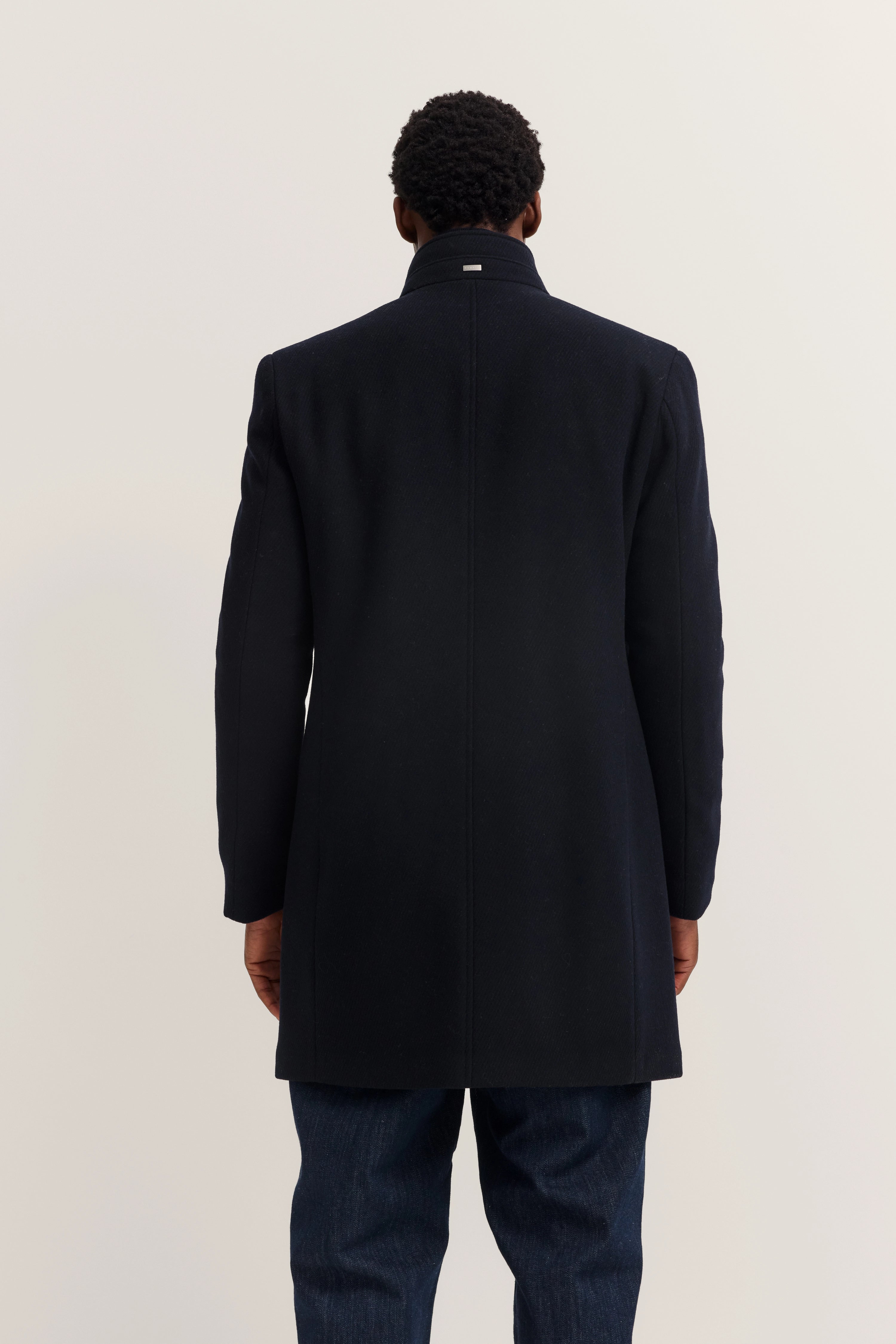 bugatti Mantel in Schwarz, Rückansicht auf Model, lässiger Look mit Jeans.