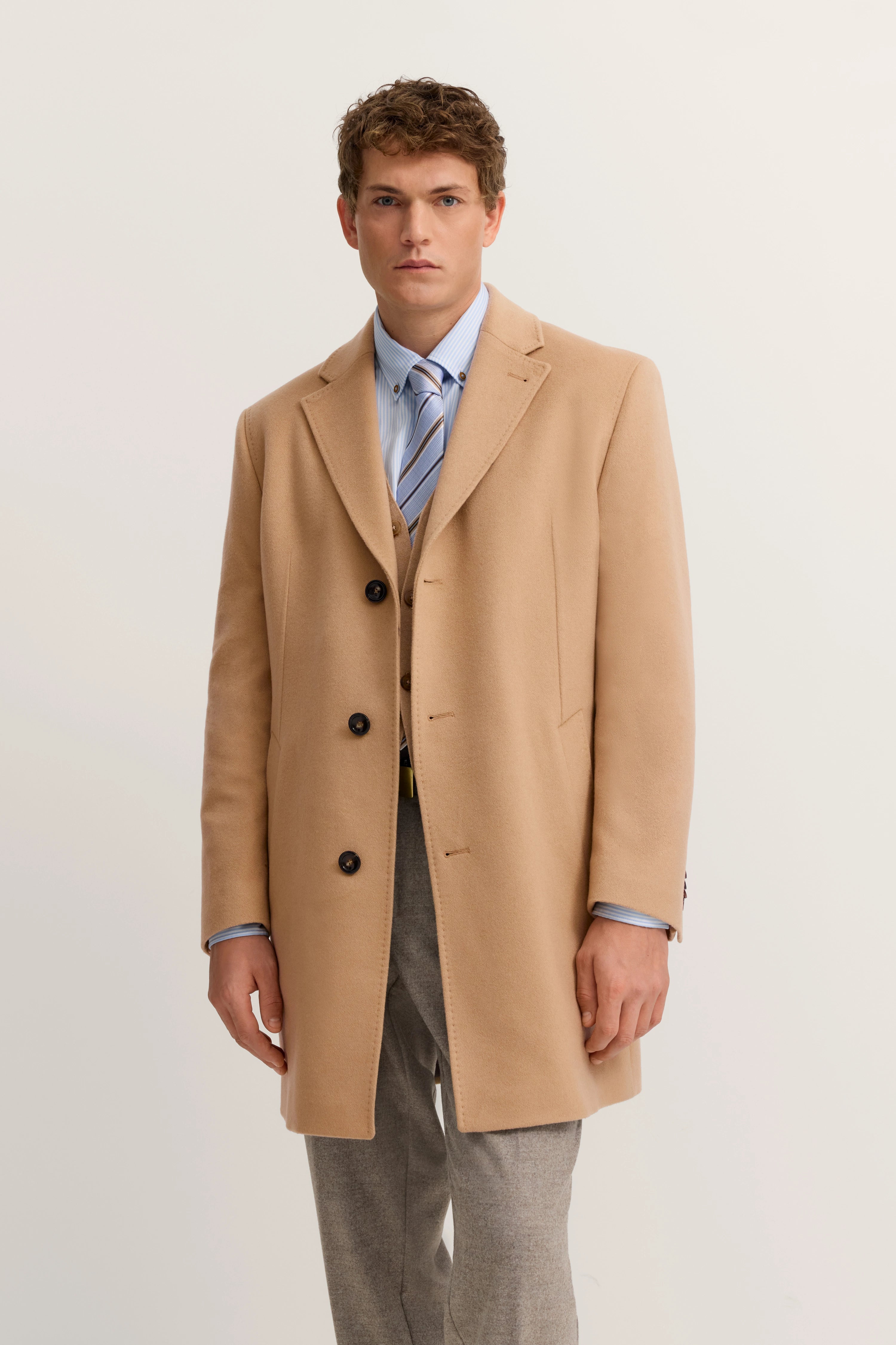 Elegantes Modelbild: Beige bugatti-Mantel, blaues Hemd, Krawatte, graue Hose