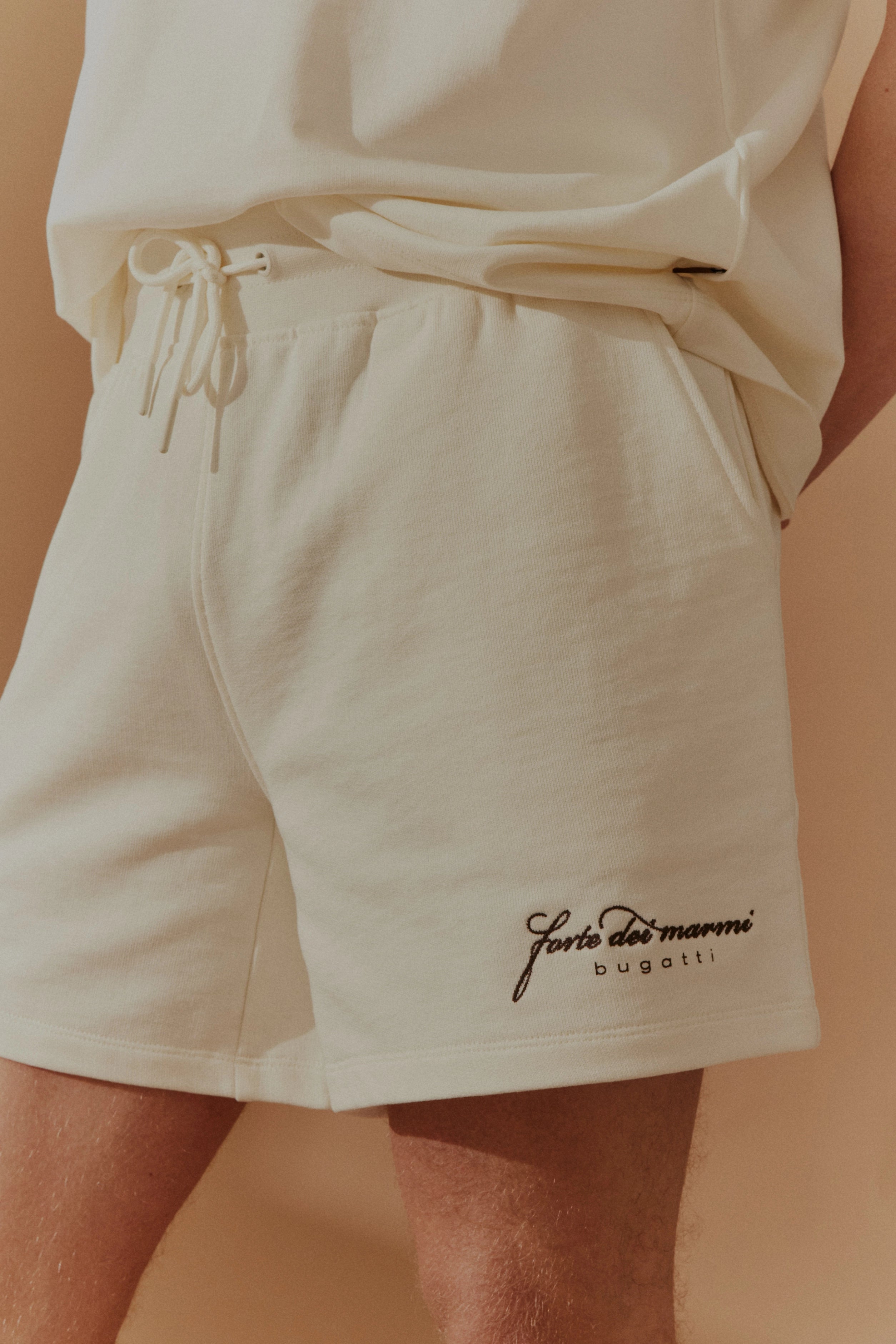 Cremefarbene Shorts mit Schriftzug, legeres Büstenbild, bugatti Stil und Eleganz.