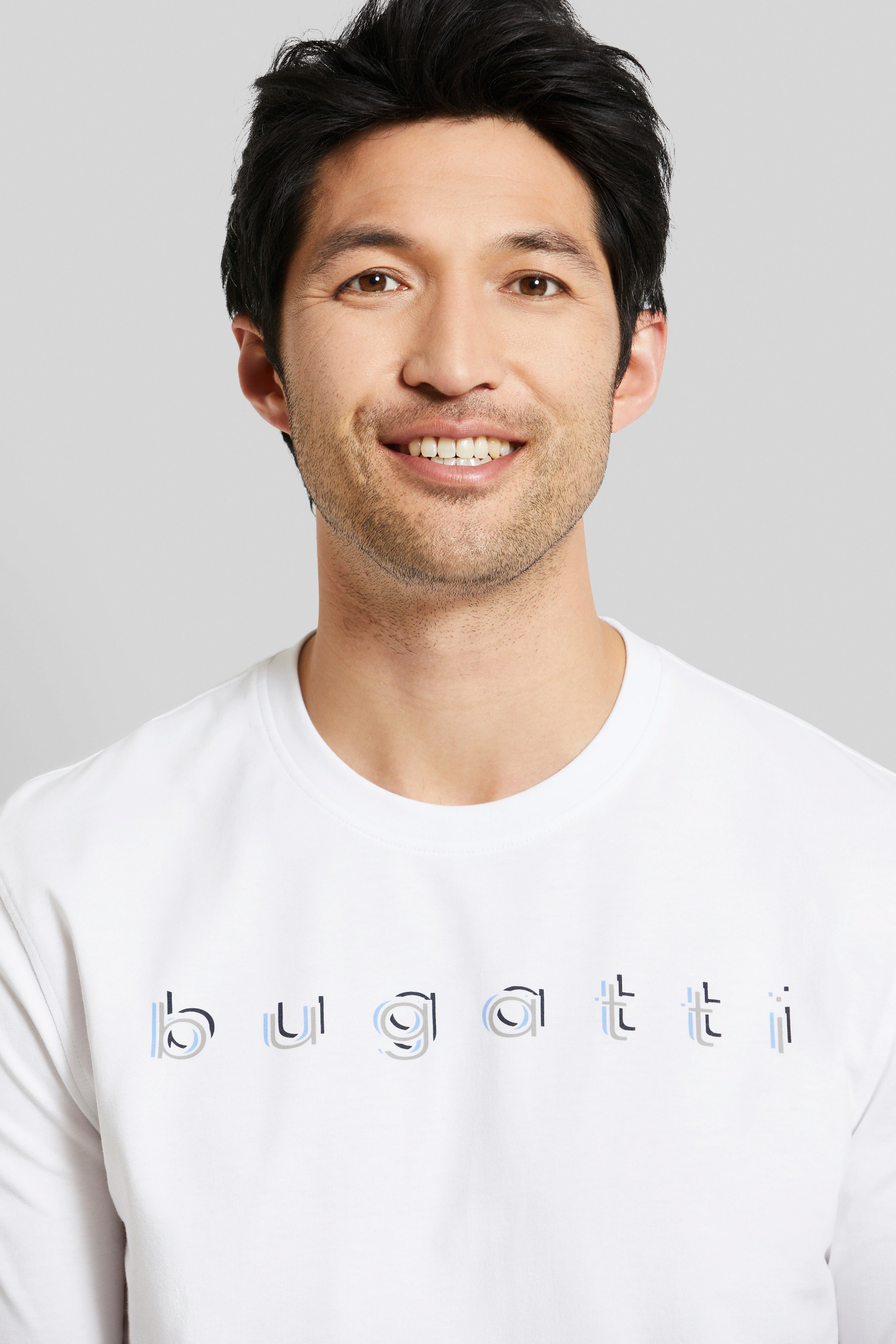 White bugatti T-shirt with logo, model smiling frontally.