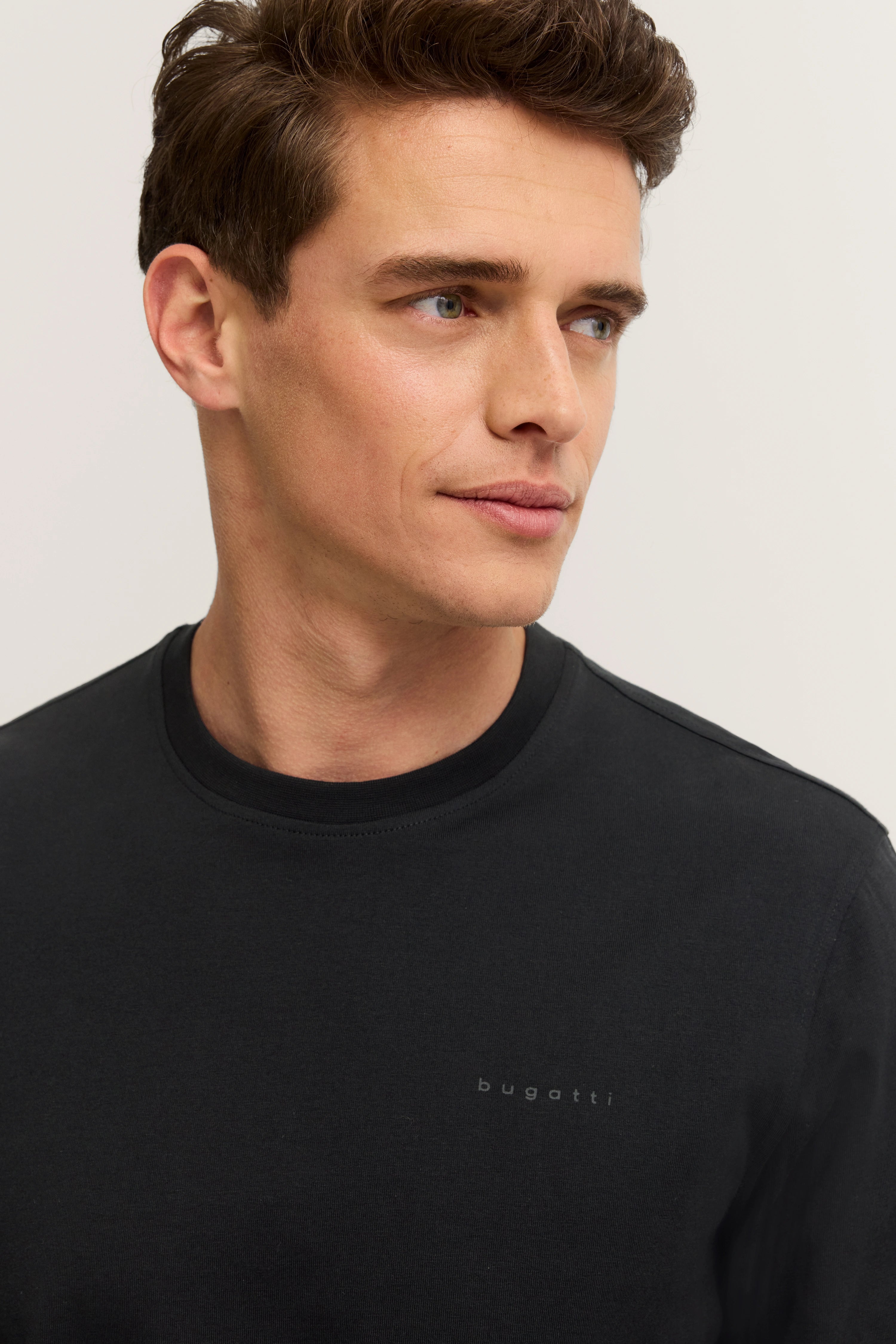 Black bugatti T-shirt, model image, relaxed expression, timeless style.