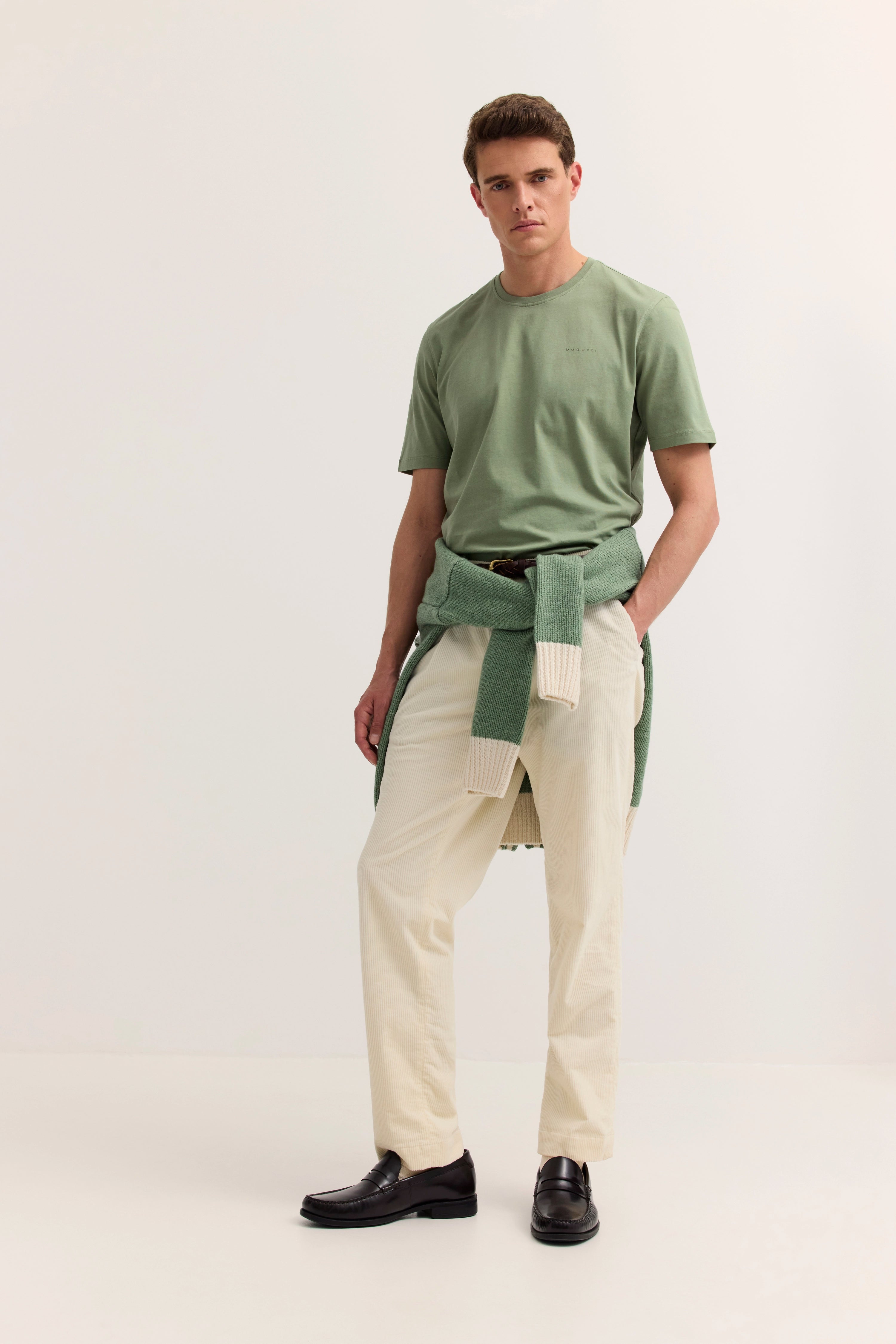bugatti Model in grünem T-Shirt, beiger Hose, grünem Pullover