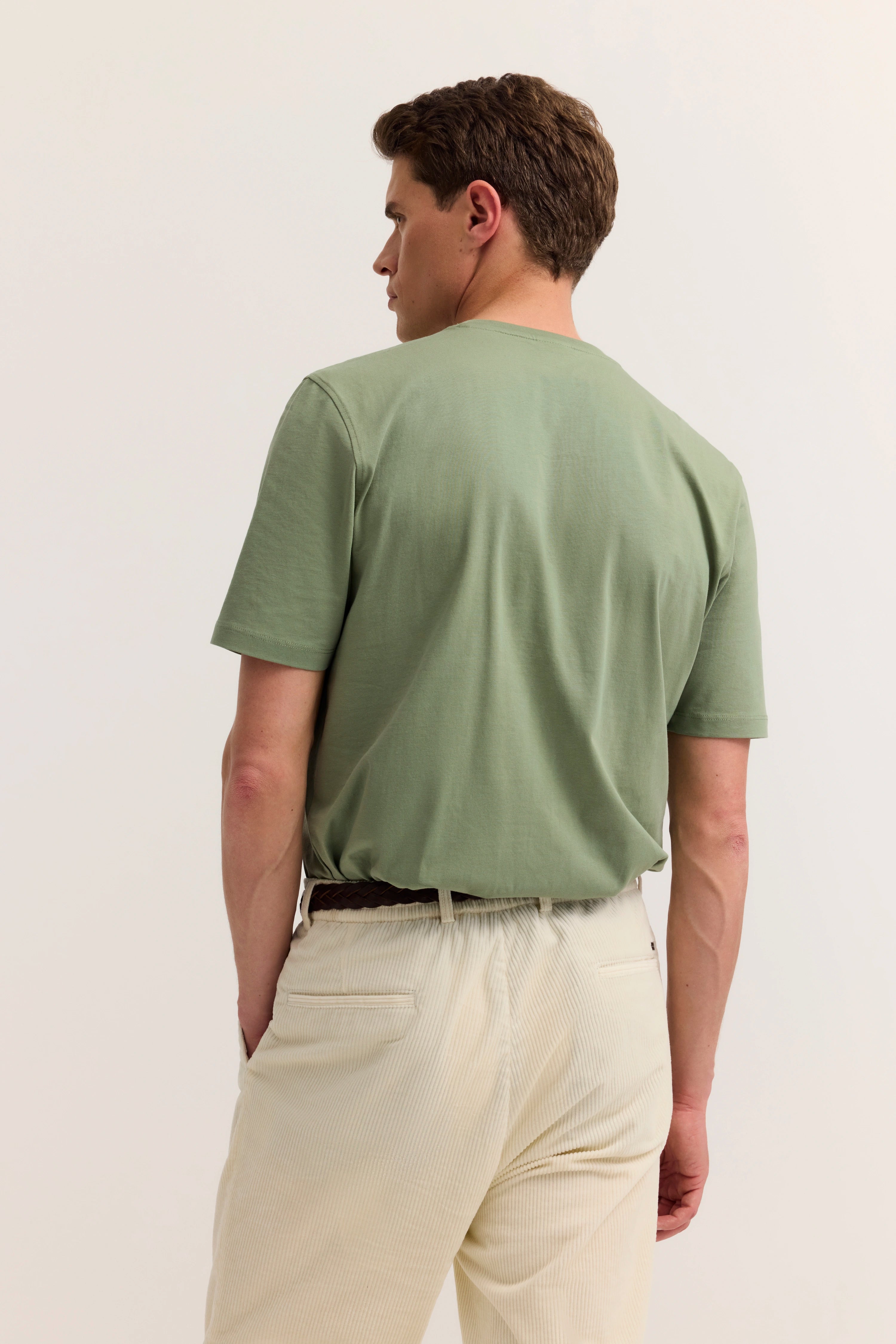 Grünes T-Shirt und beige Hose von bugatti, Model von hinten, legeres Outfit.