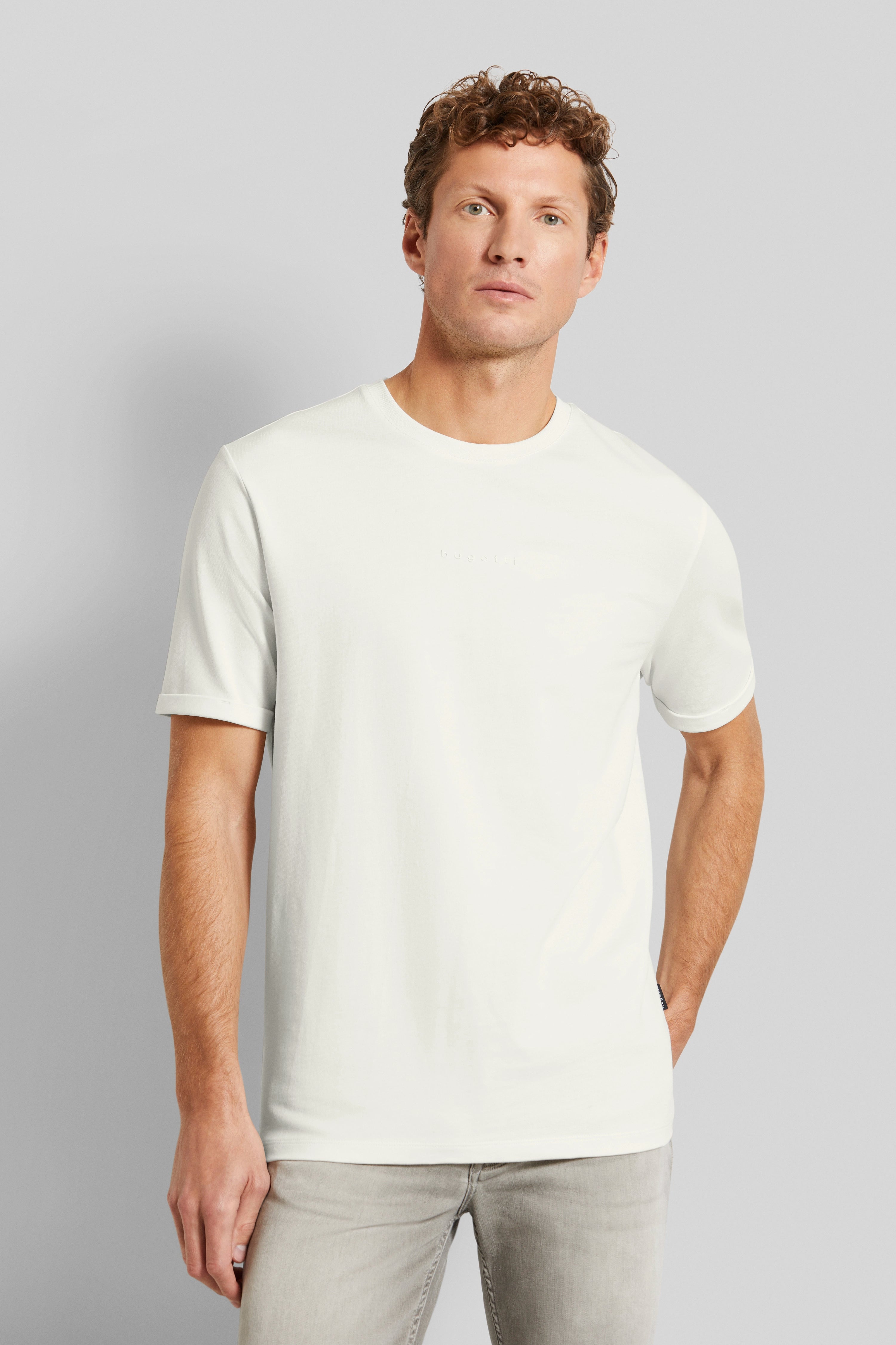 Model in white bugatti T-shirt, casual outfit, relaxed pose.
