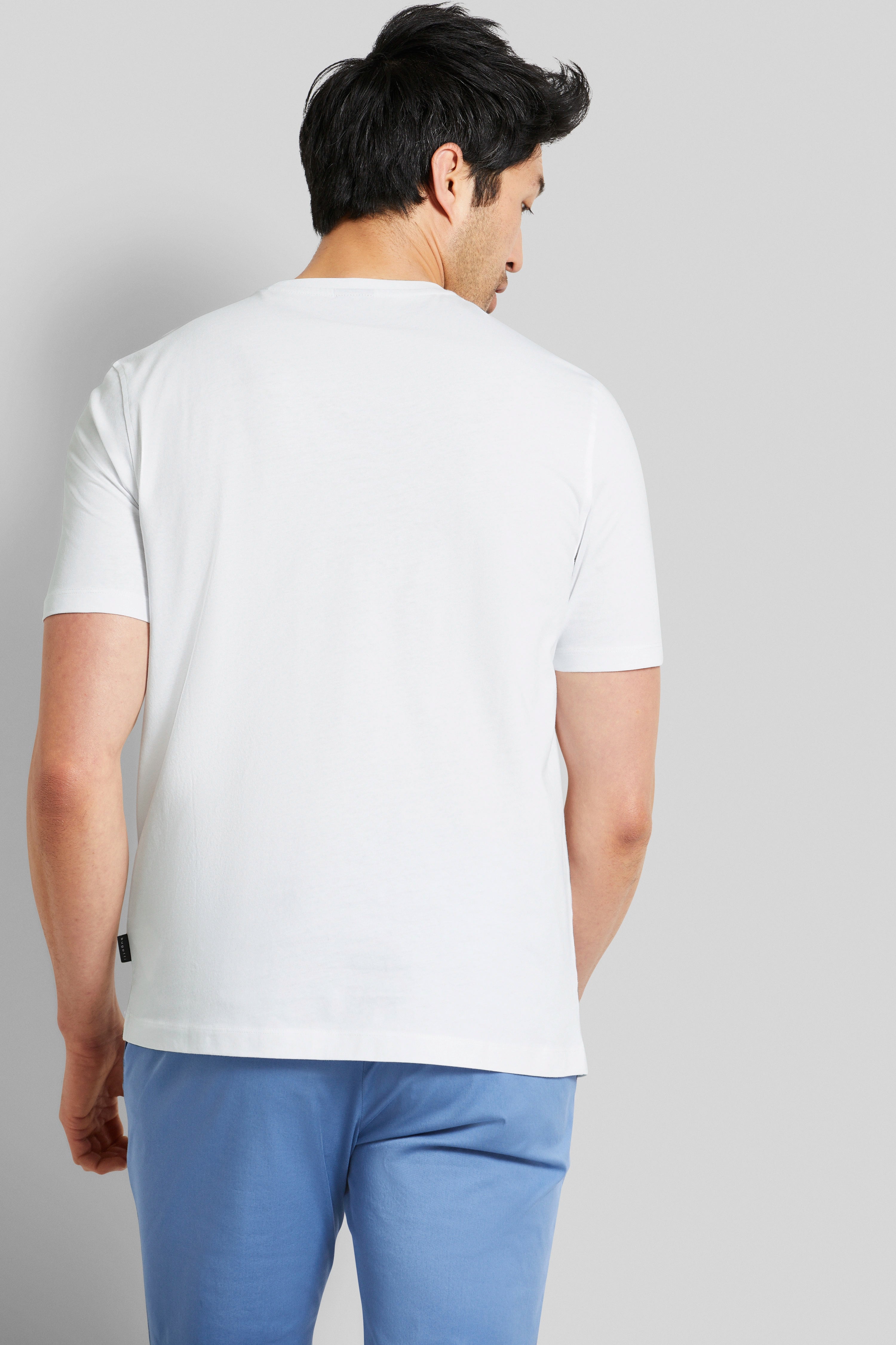 bugatti model image: white T-shirt, blue pants, back view, standing casually.