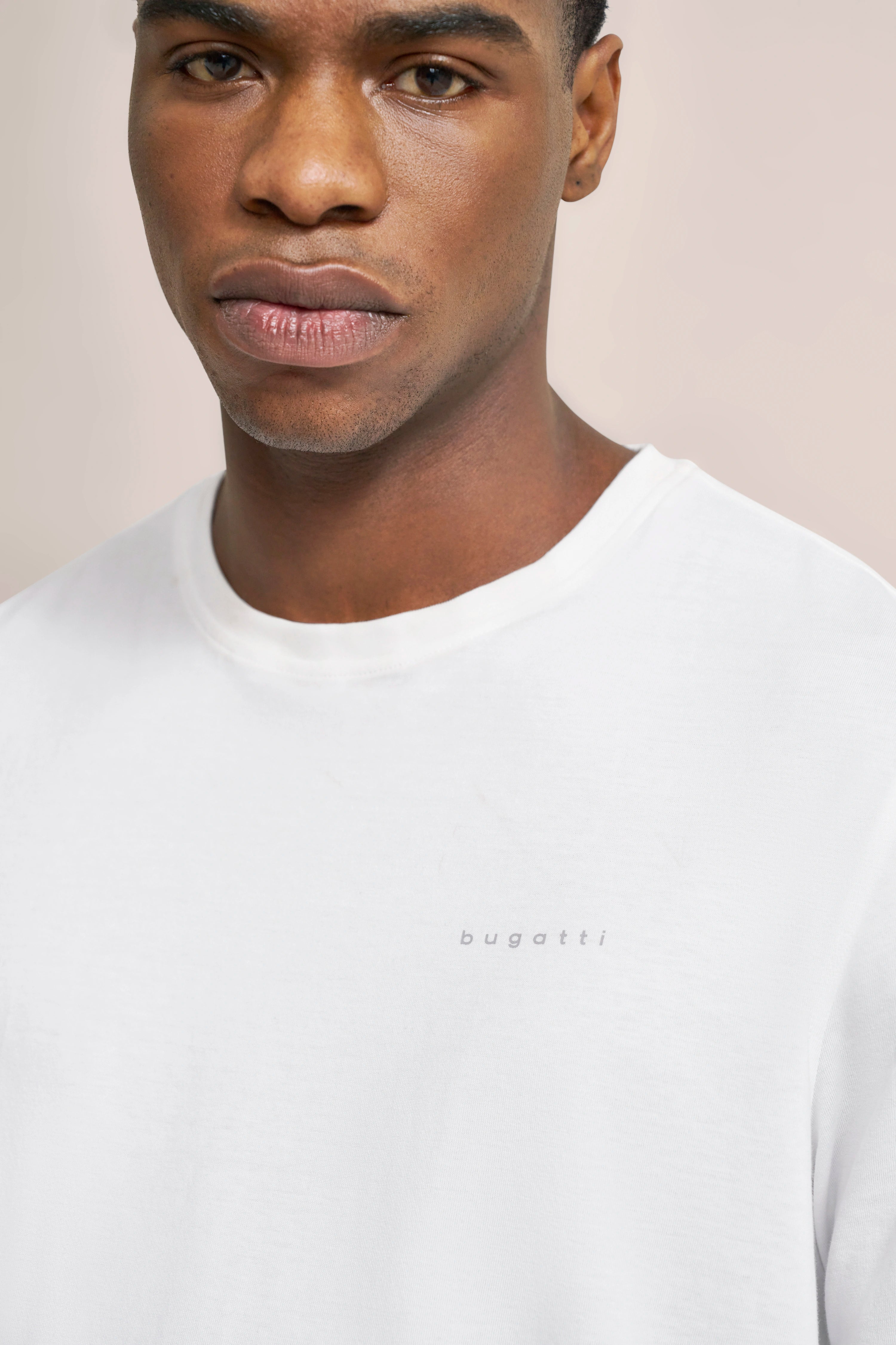 Weiße bugatti T-Shirt-Aufnahme, Büstenbild, mit dezentem Logo auf der Brust.