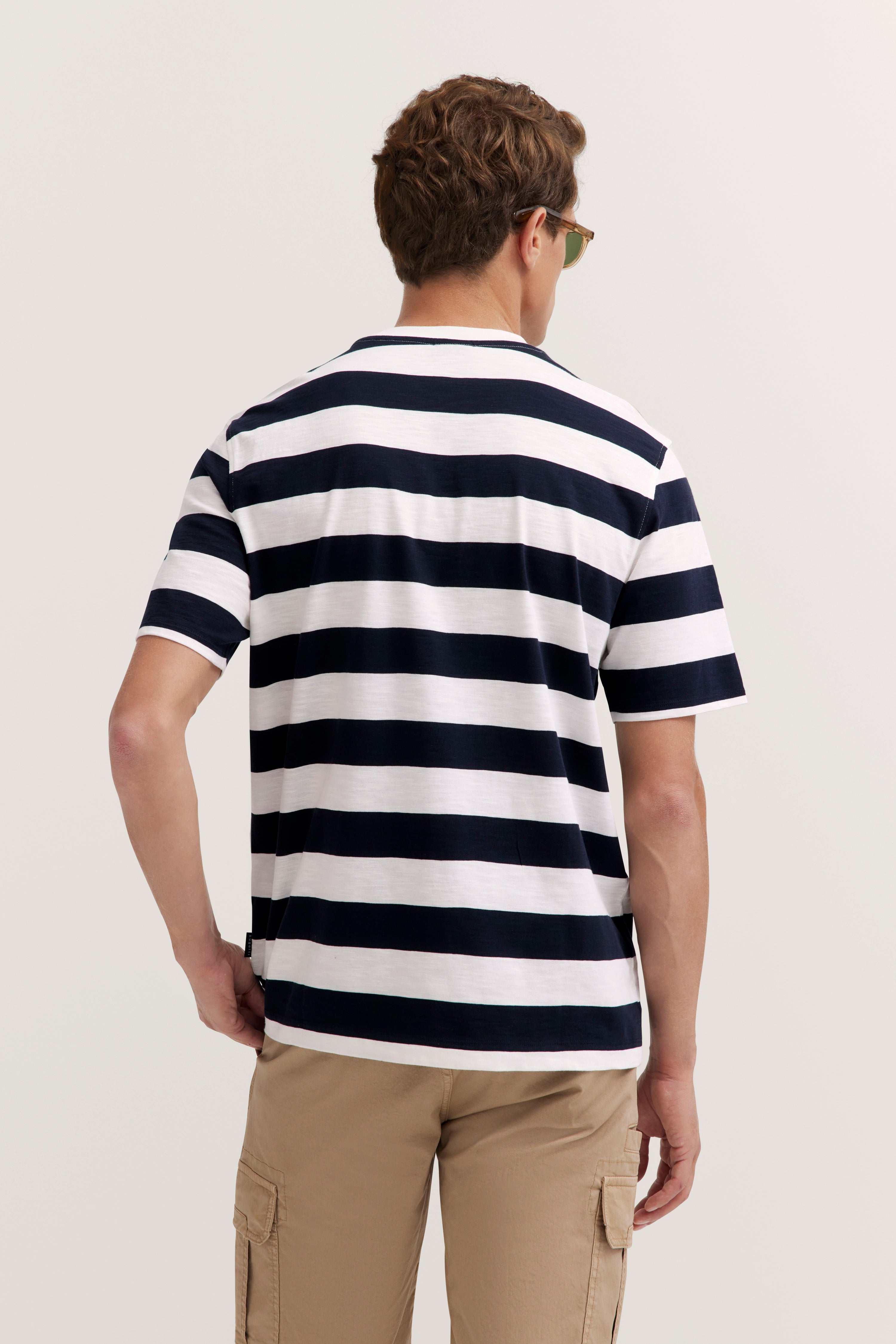 Model trägt Sonnenbrille, lässiger Stand.