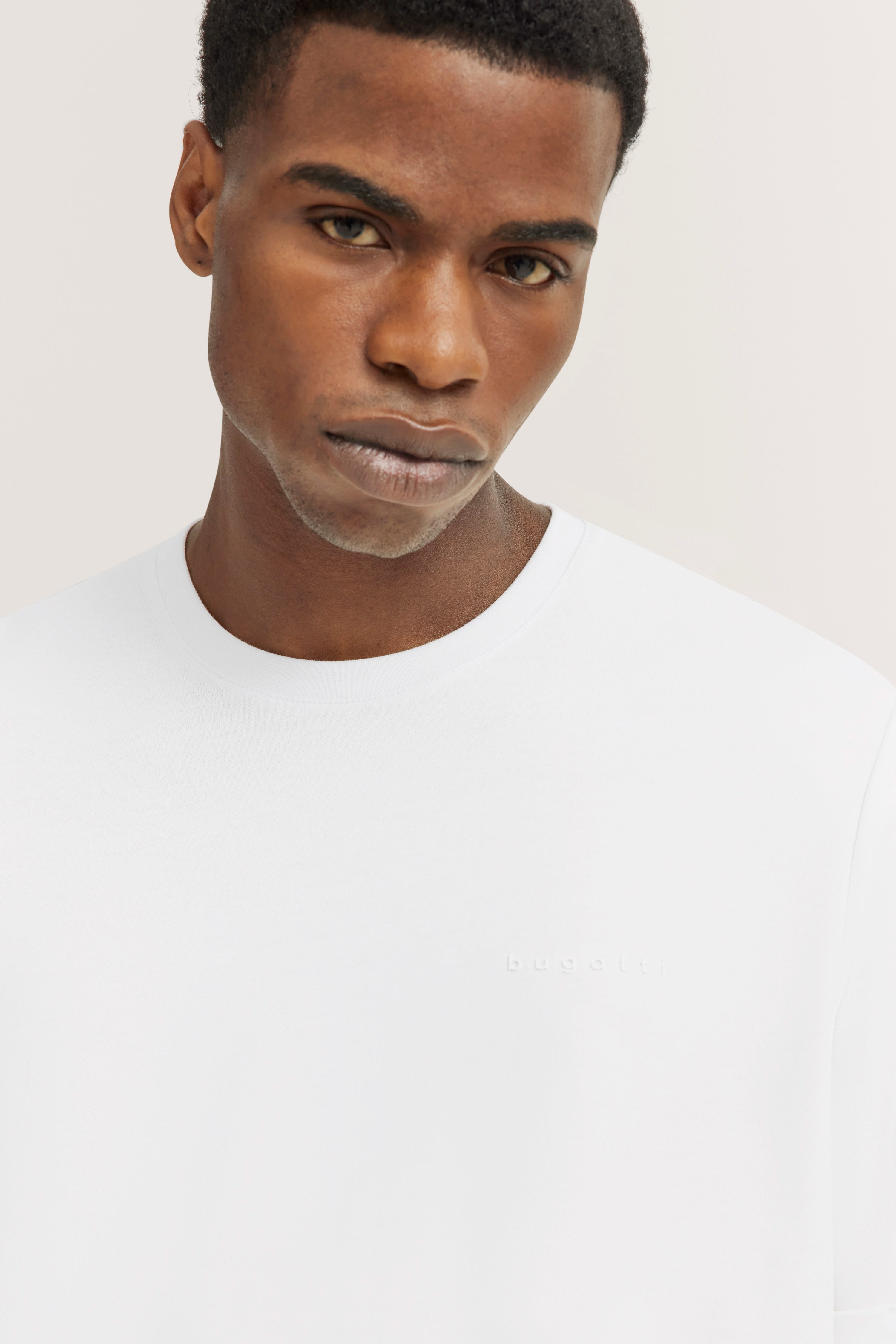 Weiße bugatti T-Shirt auf Büstenbild, minimalistisches Design, dezentes Logo.