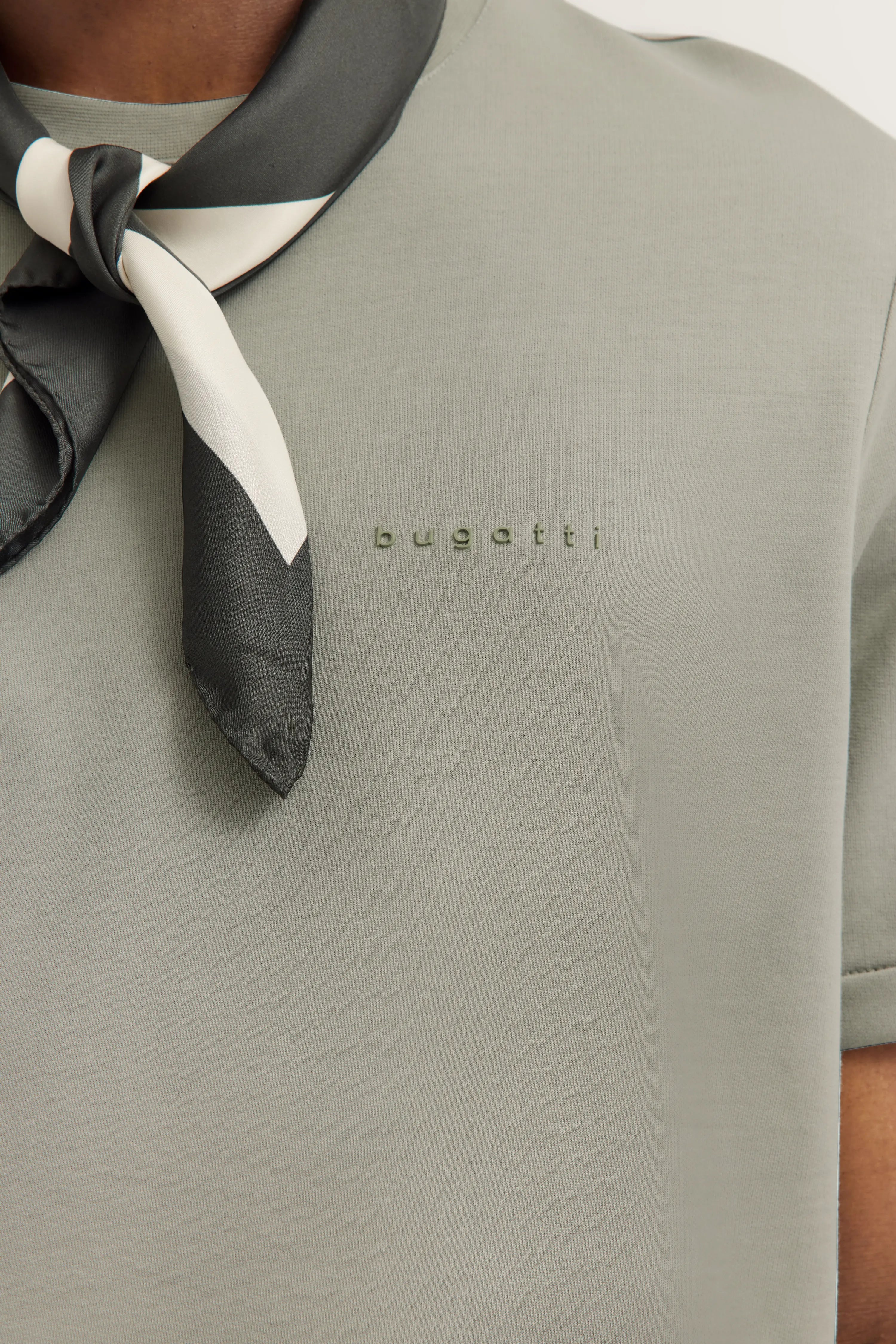 Graues bugatti T-Shirt, Nahaufnahme mit schwarzem Tuchakzent, Büstenbild.