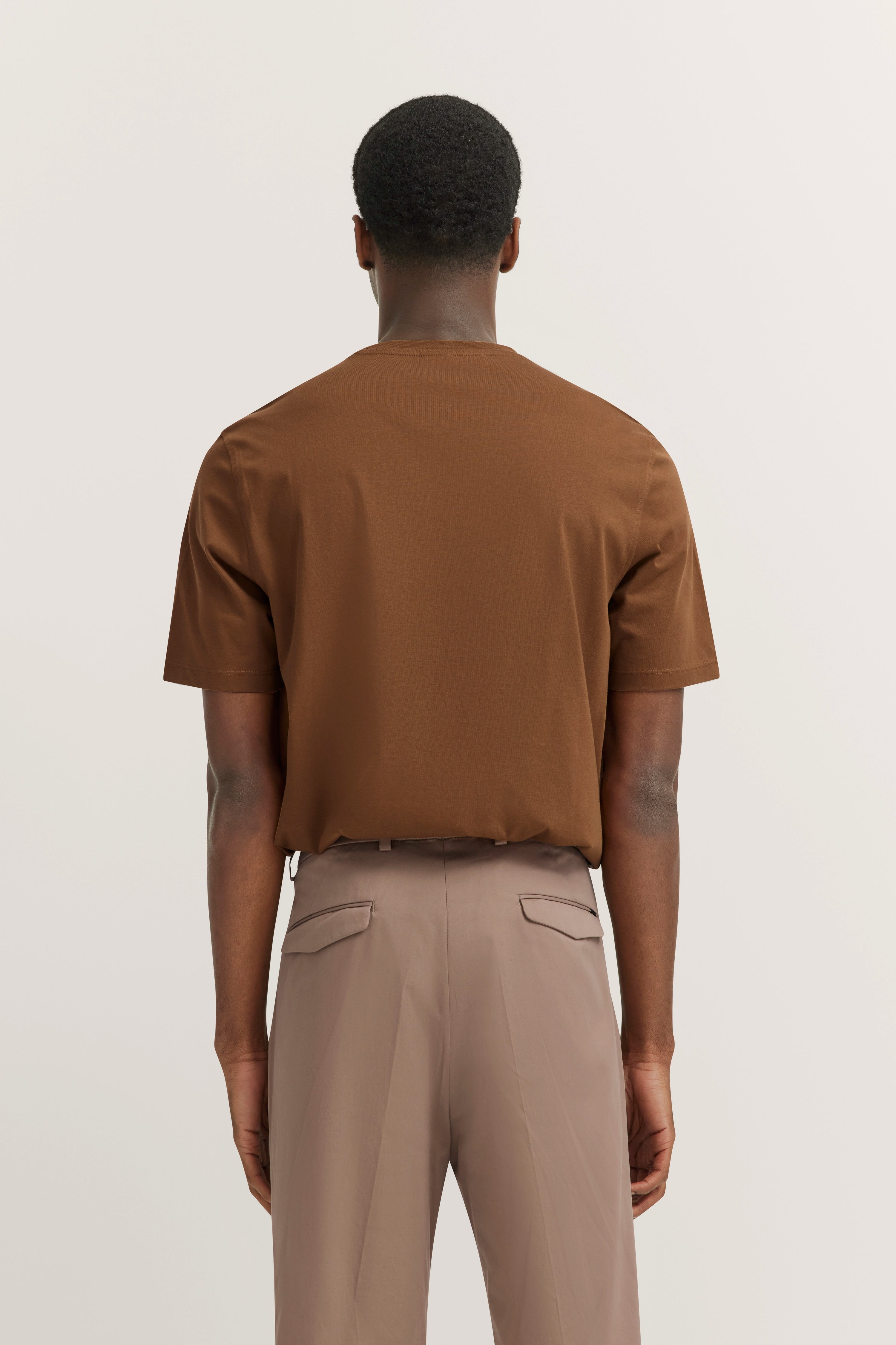Achteraanzicht model in bruin shirt en beige broek, relaxte stijl, bugatti.