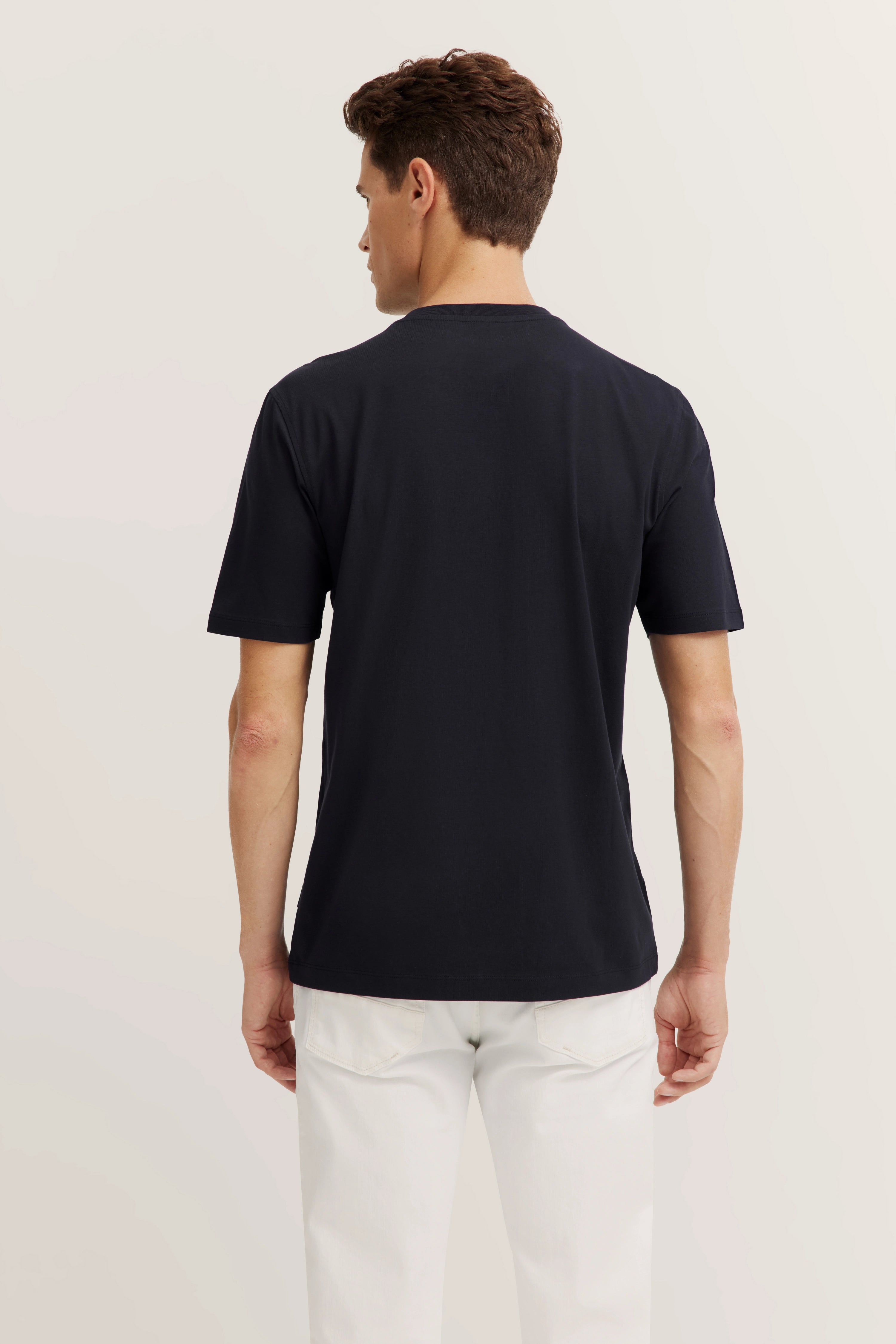 Rückansicht Modelbild mit schwarzem T-Shirt und weißen Hosen von bugatti.