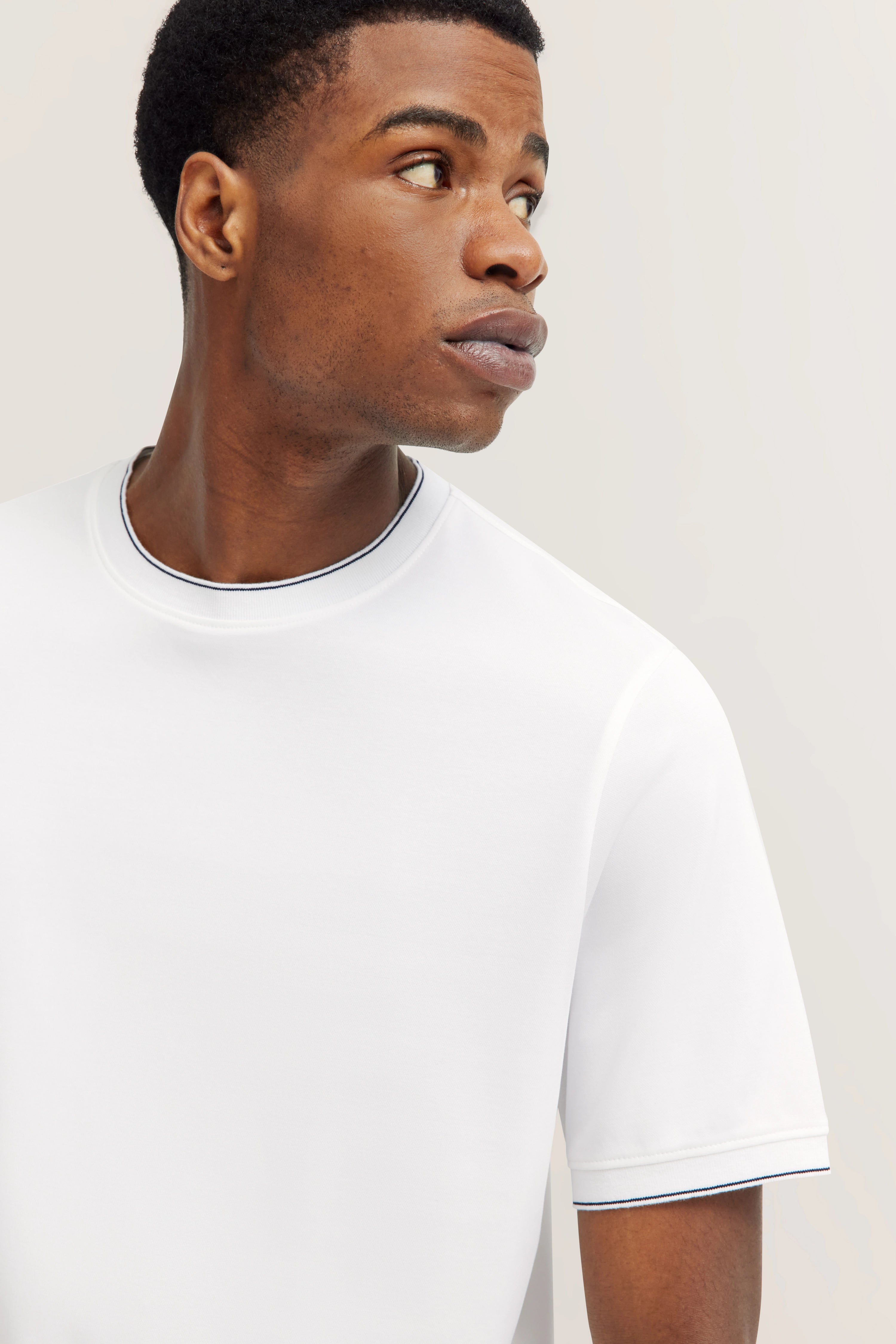 Weißes bugatti T-Shirt, Modelbild, seitlicher Blick, lässiger Stil, ideal für entspannten Alltag.