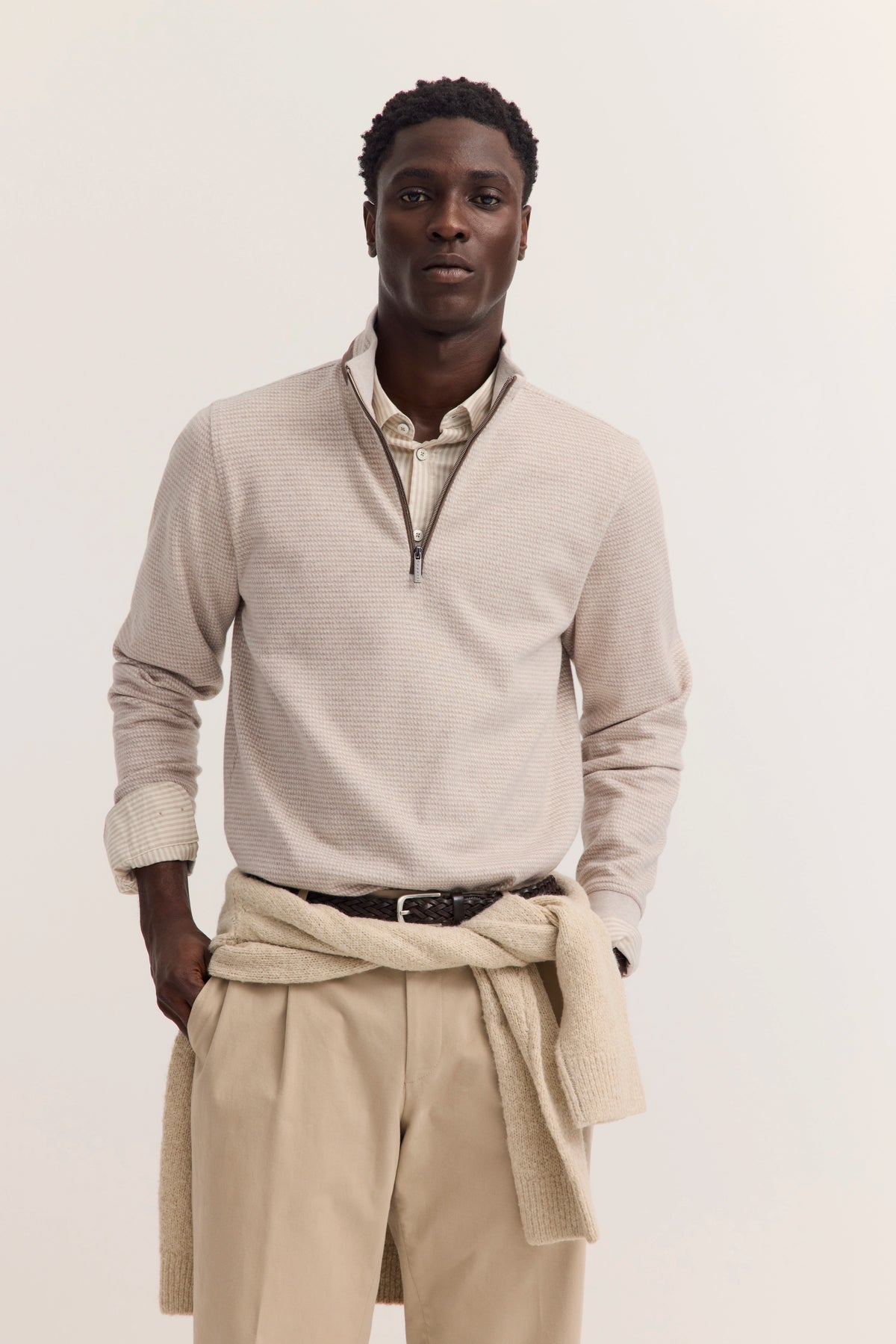 Beigefarbener Pullover und Hose mit Hemd, legerer Stil, Model mit entspannter Pose, bugatti.