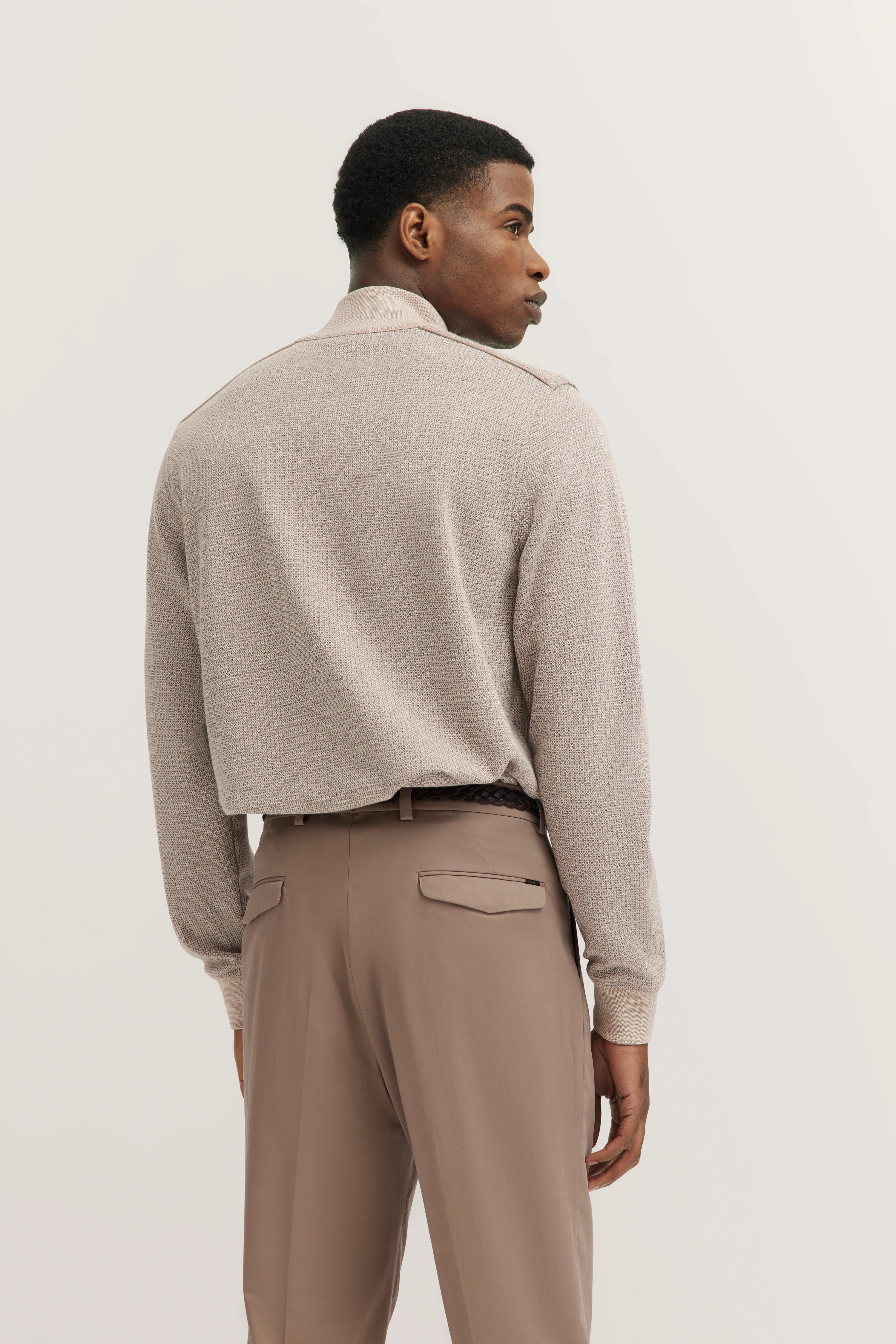 Model in beigem Pullover und brauner Hose von bugatti, Rückansicht, entspannte Pose.