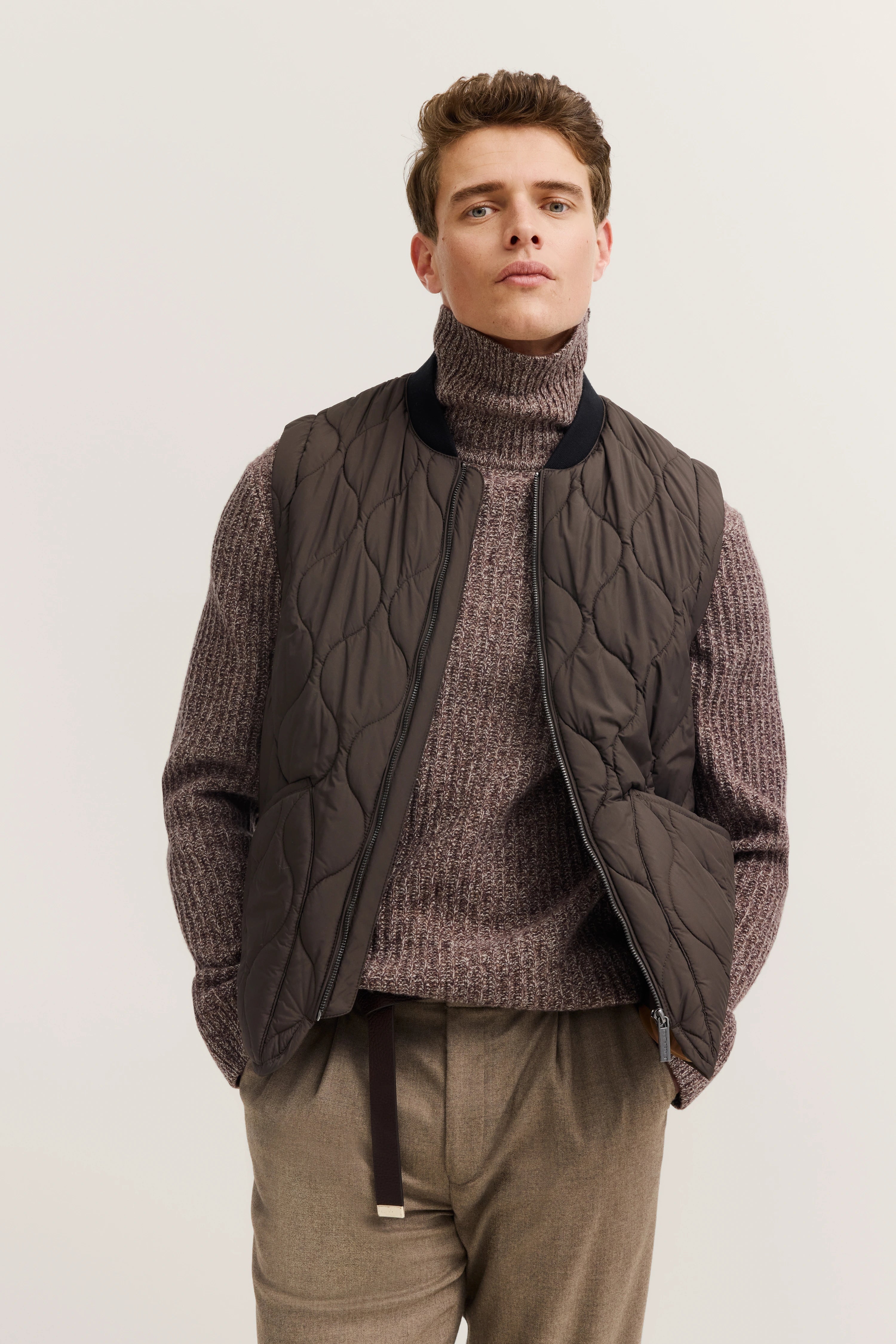 Brown quilted vest, beige knit sweater, beige pants