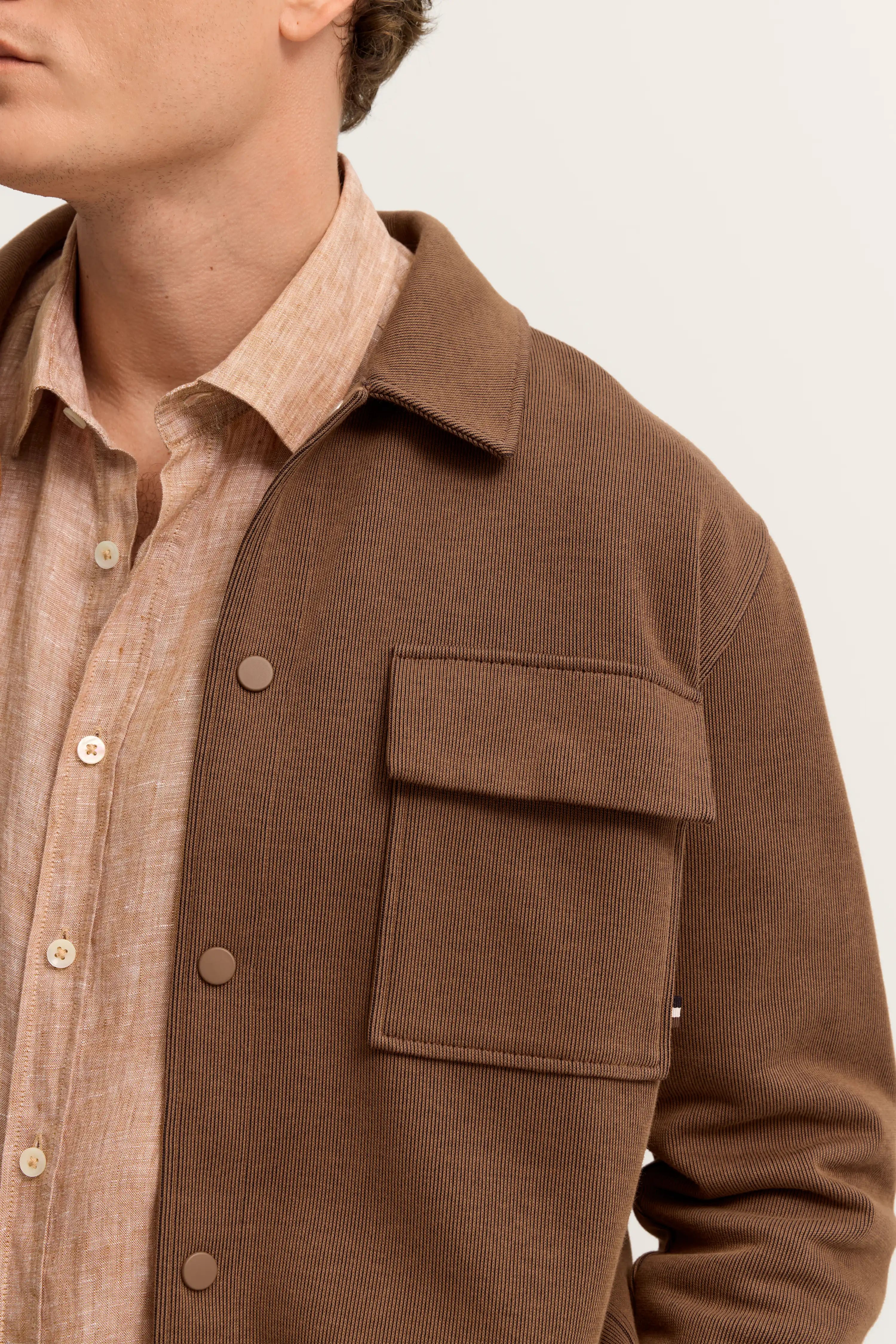 Braunes bugatti Hemdjacke über beige Leinenhemd, Büstenbild, klassisch-eleganter Stil.