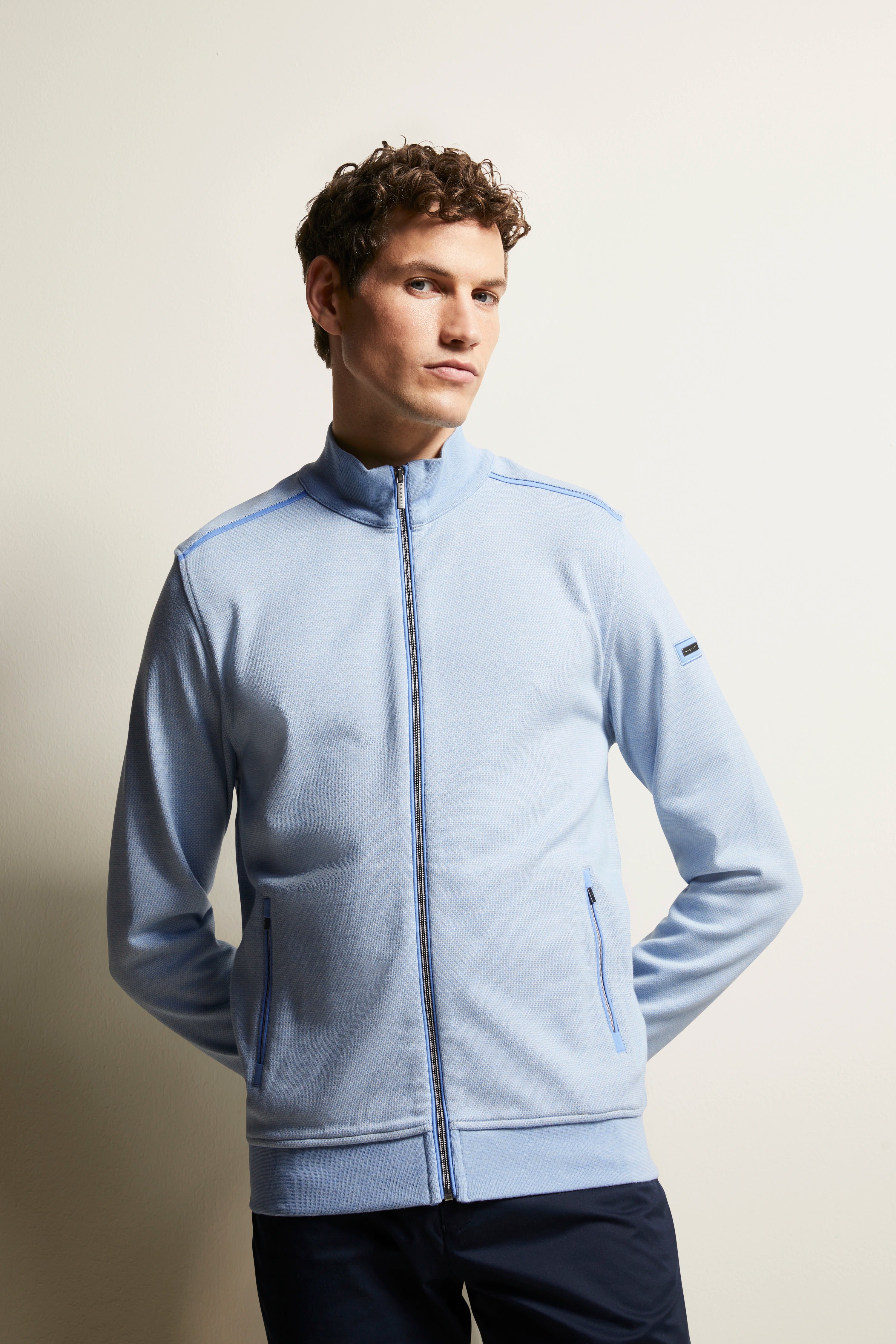 Model wearing light blue bugatti jacket with zipper, dark pants